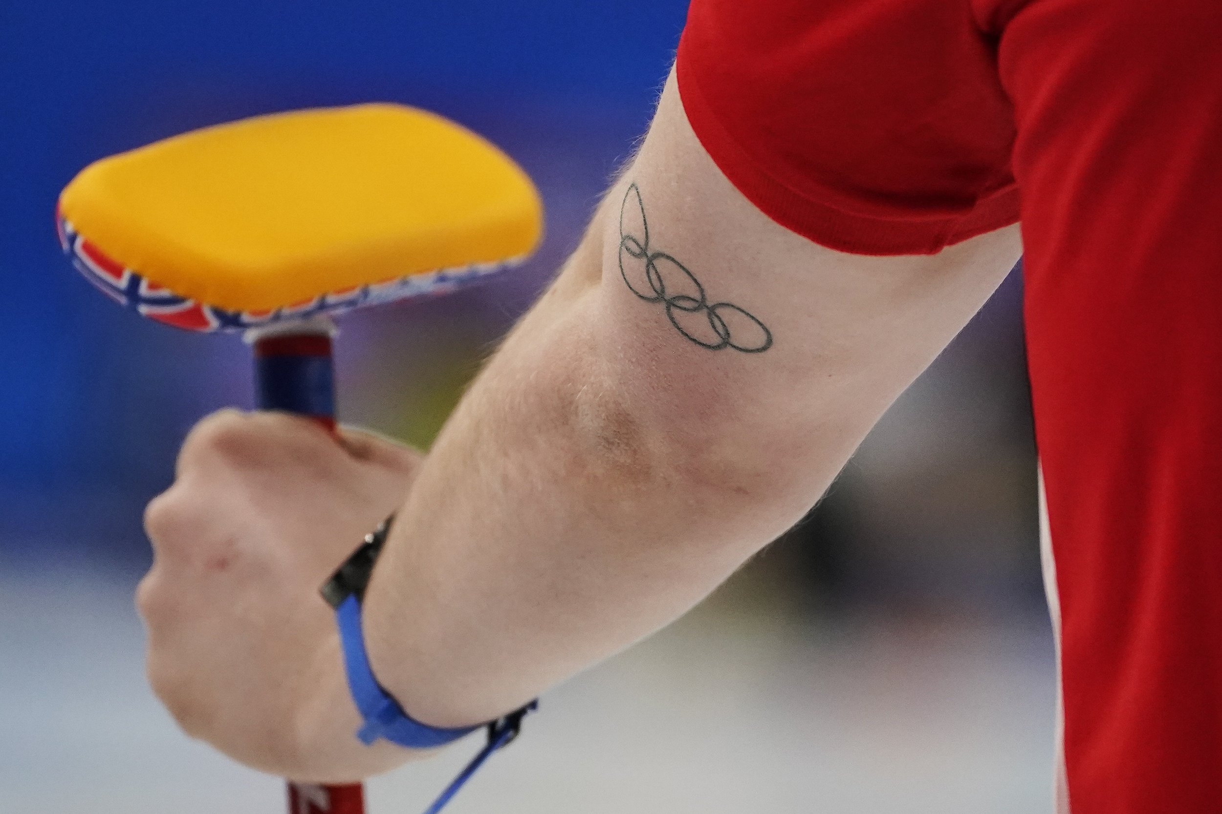  Magnus Nedregotten, of Norway, holds a brush and has an Olympic rings tattoo on his arm during the mixed doubles curling match against the Czech Republic at the Beijing Winter Olympics Wednesday, Feb. 2, 2022, in Beijing. (AP Photo/Brynn Anderson) 