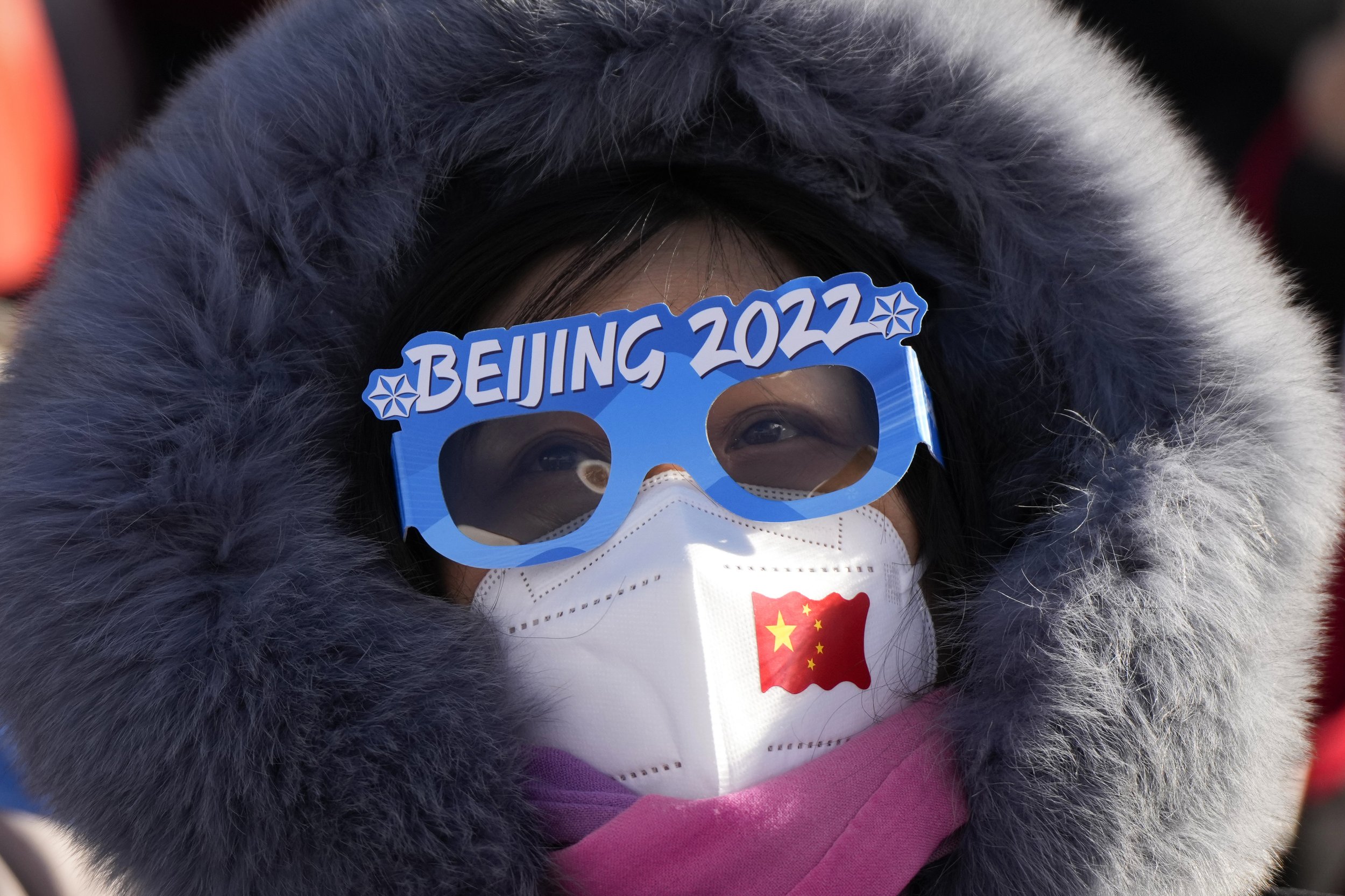  A spectator watching the women's parallel giant slalom qualification run at the 2022 Winter Olympics, Tuesday, Feb. 8, 2022, in Zhangjiakou, China. (AP Photo/Francisco Seco) 