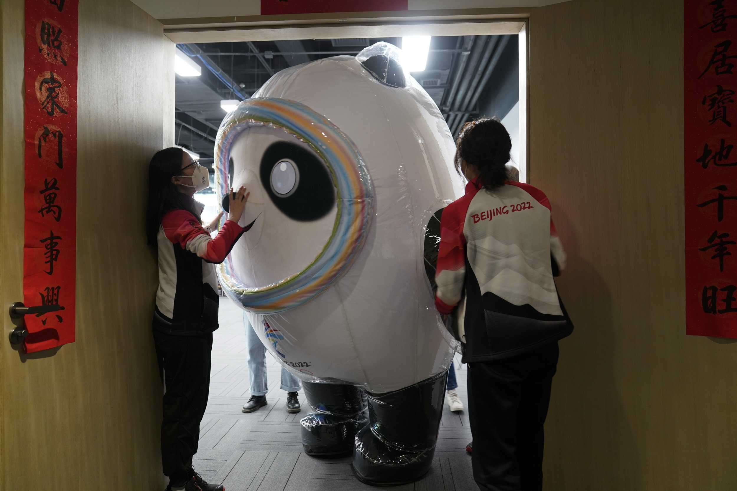  Bing Dwen Dwen, the mascot of the Beijing 2022, turns sideways to exit through the doors after visiting the Xinhua news agency's office at the 2022 Winter Olympics, Tuesday, Feb. 8, 2022, in Beijing. (AP Photo/Jae C. Hong) 