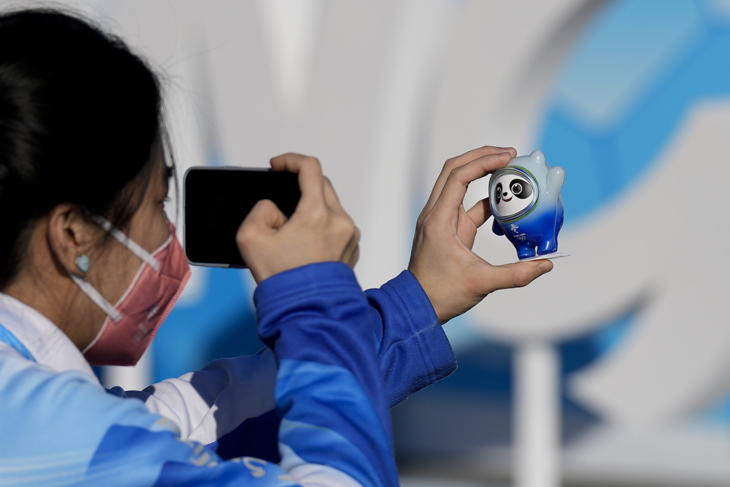  A woman takes a picture of the Olympic mascot, Bing Dwen Dwen, at the Olympic Green ahead of the 2022 Winter Olympics, Feb. 1, 2022, in Beijing. (AP Photo/Natacha Pisarenko) 
