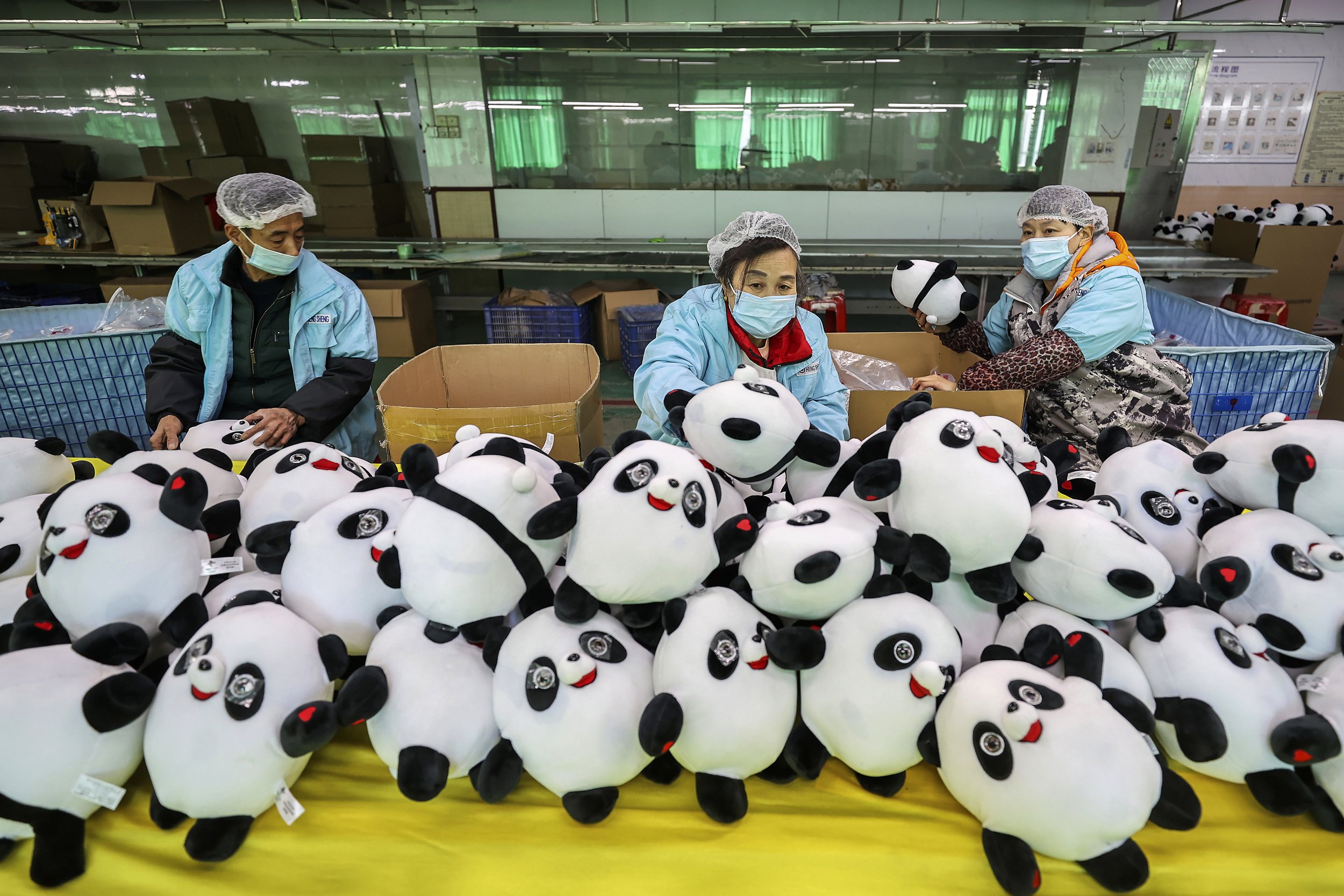  Workers at a factory manufacture Bing Dwen Dwen stuffed dolls, the mascot of 2022 Winter Olympics, in Jinjiang city in southeastern China's Fujian province Tuesday, Feb. 8, 2022. (Chinatopix via AP) 