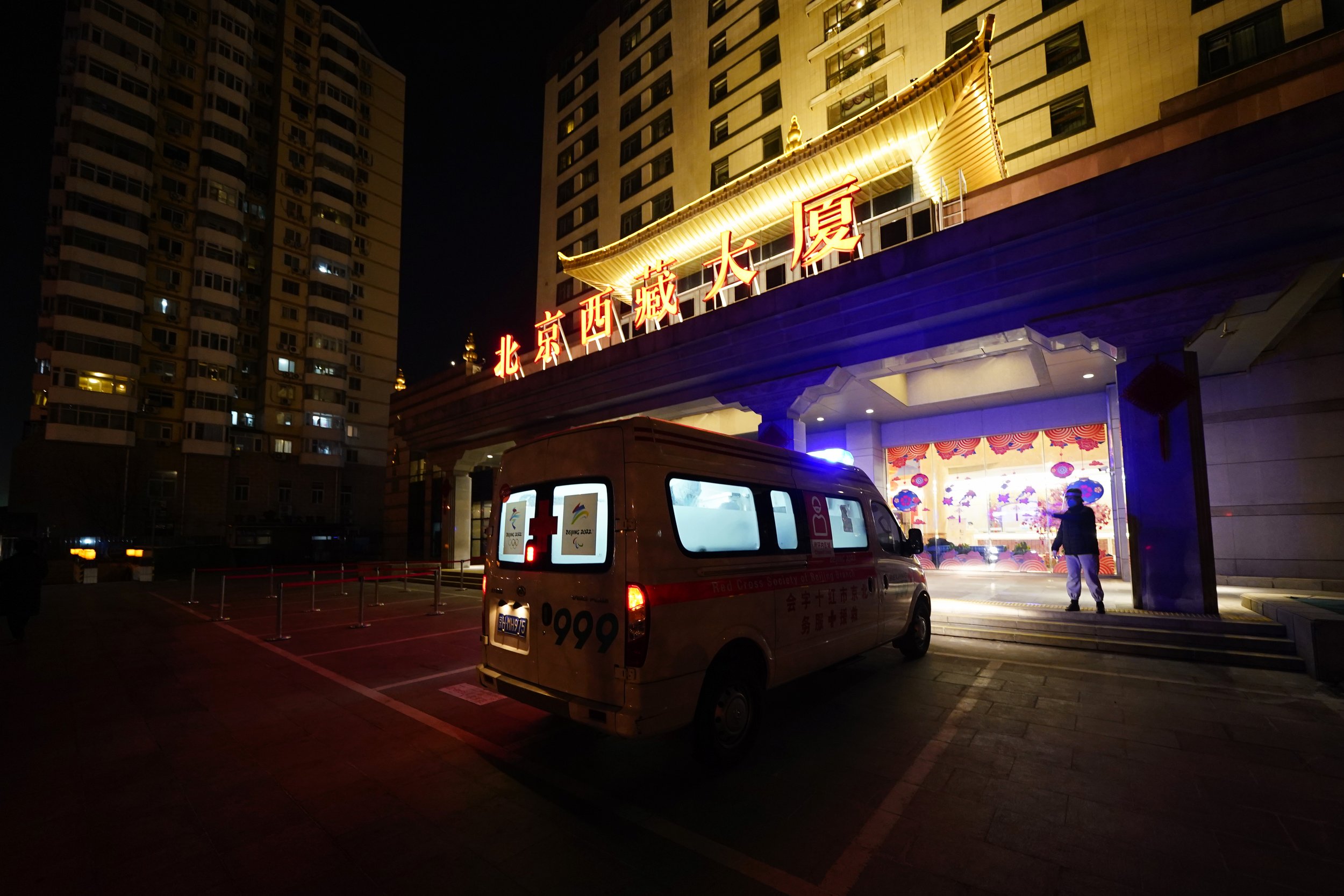  A medical worker directs an ambulance outside a hotel after transporting Associated Press photographer Matt Slocum following a positive coronavirus test during the 2022 Winter Olympics, Feb. 9, 2022, in Beijing. (AP Photo/Matt Slocum) 