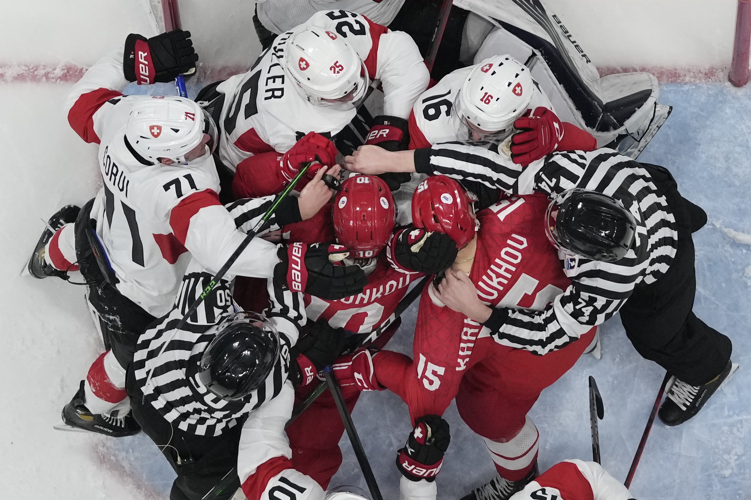  Russian Olympic Committee and Switzerland players fight as officials try to separate them during a preliminary round men's hockey game at the 2022 Winter Olympics, Wednesday, Feb. 9, 2022, in Beijing. (AP Photo/Matt Slocum) 