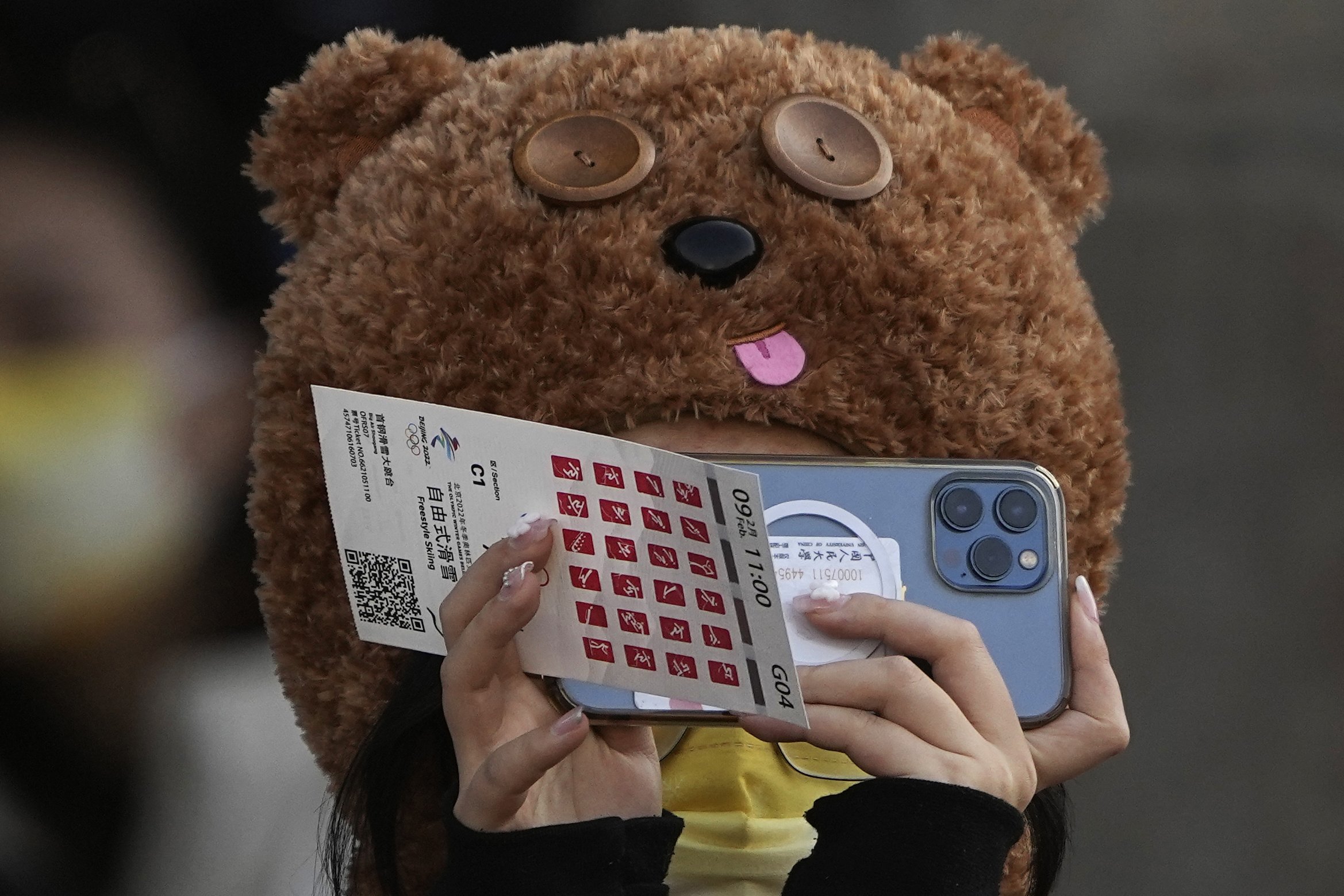  A spectator takes a picture ahead of the men's freestyle skiing big air finals of the 2022 Winter Olympics, Wednesday, Feb. 9, 2022, in Beijing. (AP Photo/Jae C. Hong) 