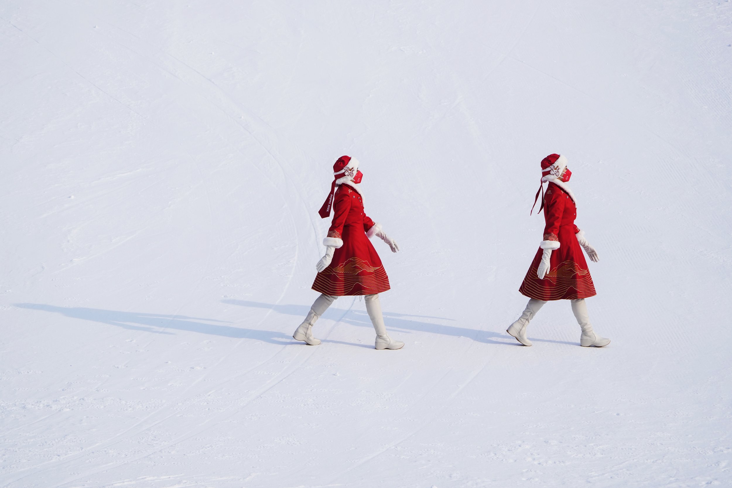  Hostesses walk during the award ceremony for the the women's slalom at the 2022 Winter Olympics, Wednesday, Feb. 9, 2022, in the Yanqing district of Beijing.(AP Photo/Pavel Golovkin) 