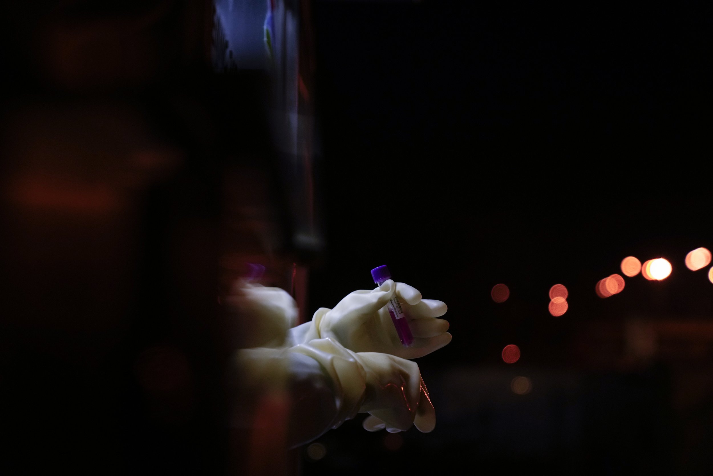  A worker holds a COVID-19 test at the 2022 Winter Olympics, Thursday, Feb. 10, 2022, in Beijing. (AP Photo/Natacha Pisarenko) 