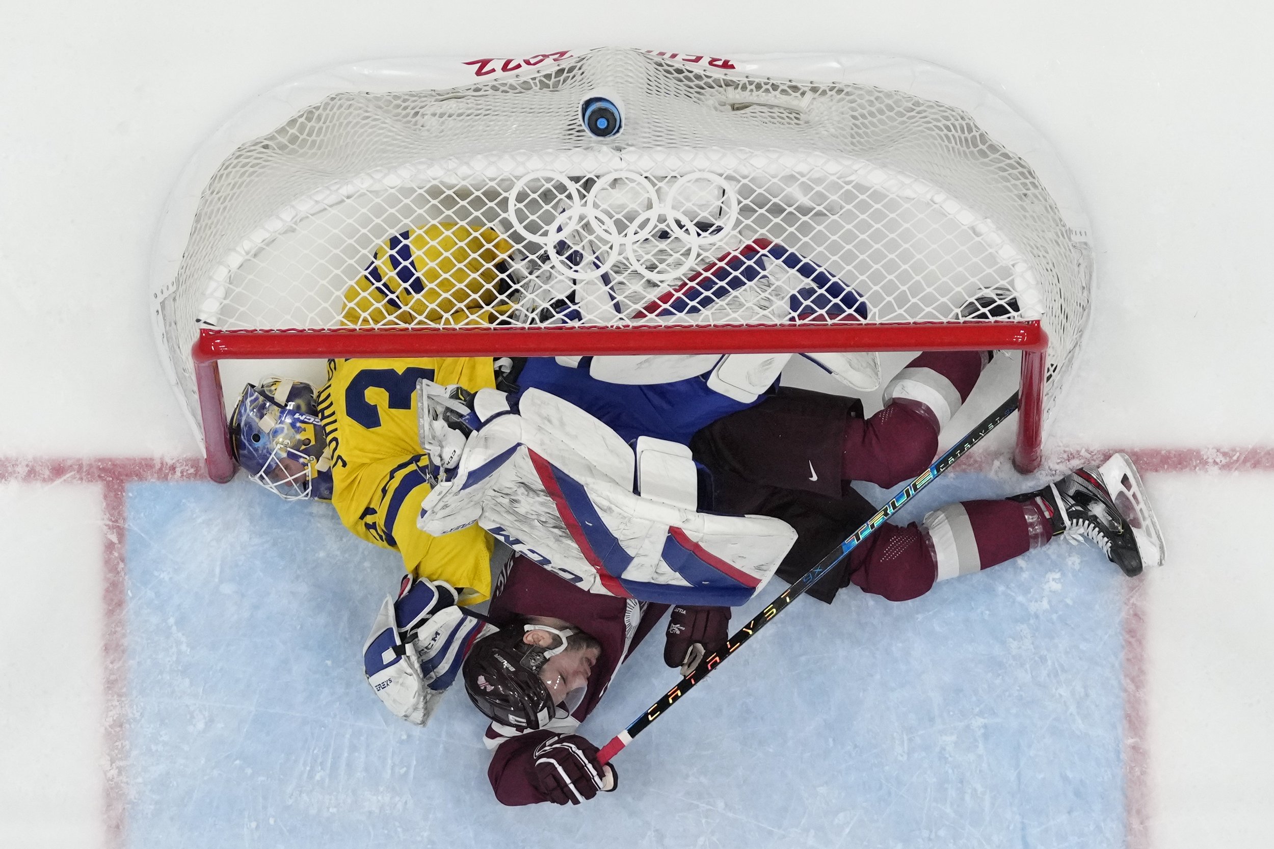  Latvia's Martins Dzierkals, bottom, winds up under Sweden goalkeeper Lars Johansson (31) after they collided during a preliminary round men's hockey game at the 2022 Winter Olympics, Thursday, Feb. 10, 2022, in Beijing. (AP Photo/Matt Slocum) 