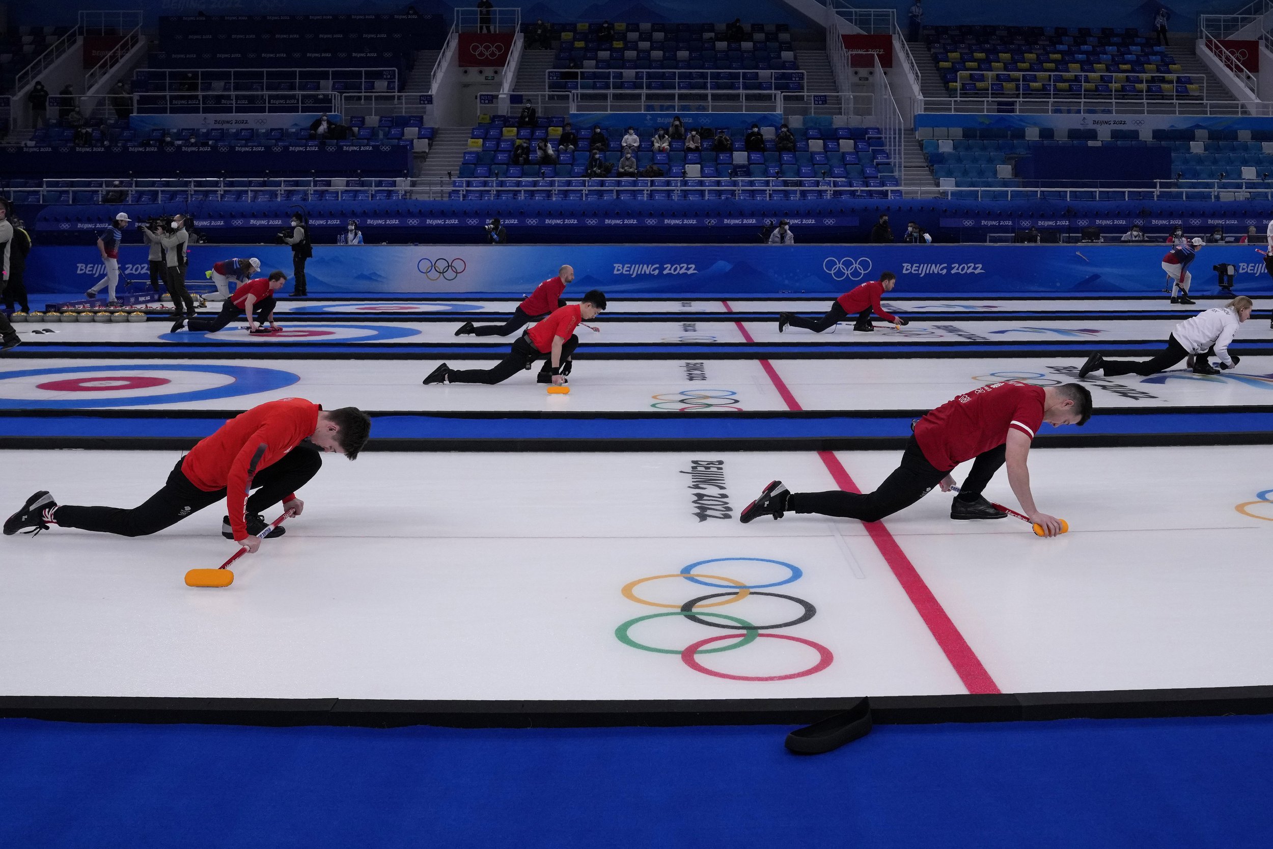  Men's teams warm up before their curling matches, at the 2022 Winter Olympics, Thursday, Feb. 10, 2022, in Beijing. (AP Photo/Nariman El-Mofty) 