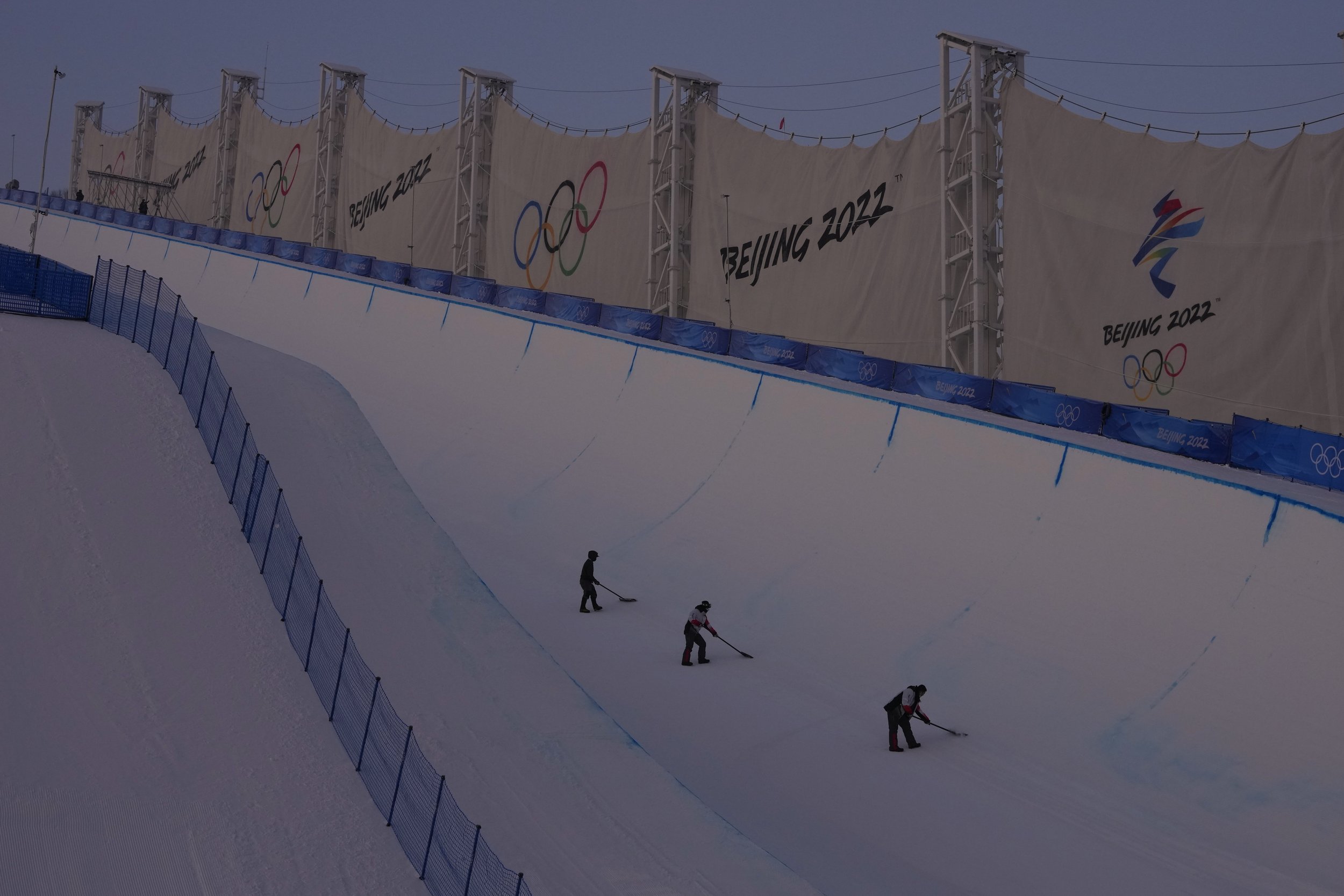  Workers prepare the halfpipe course at Genting Snow Park before the women's halfpipe finals at the 2022 Winter Olympics, Thursday, Feb. 10, 2022, in Zhangjiakou, China. (AP Photo/Kiichiro Sato) 
