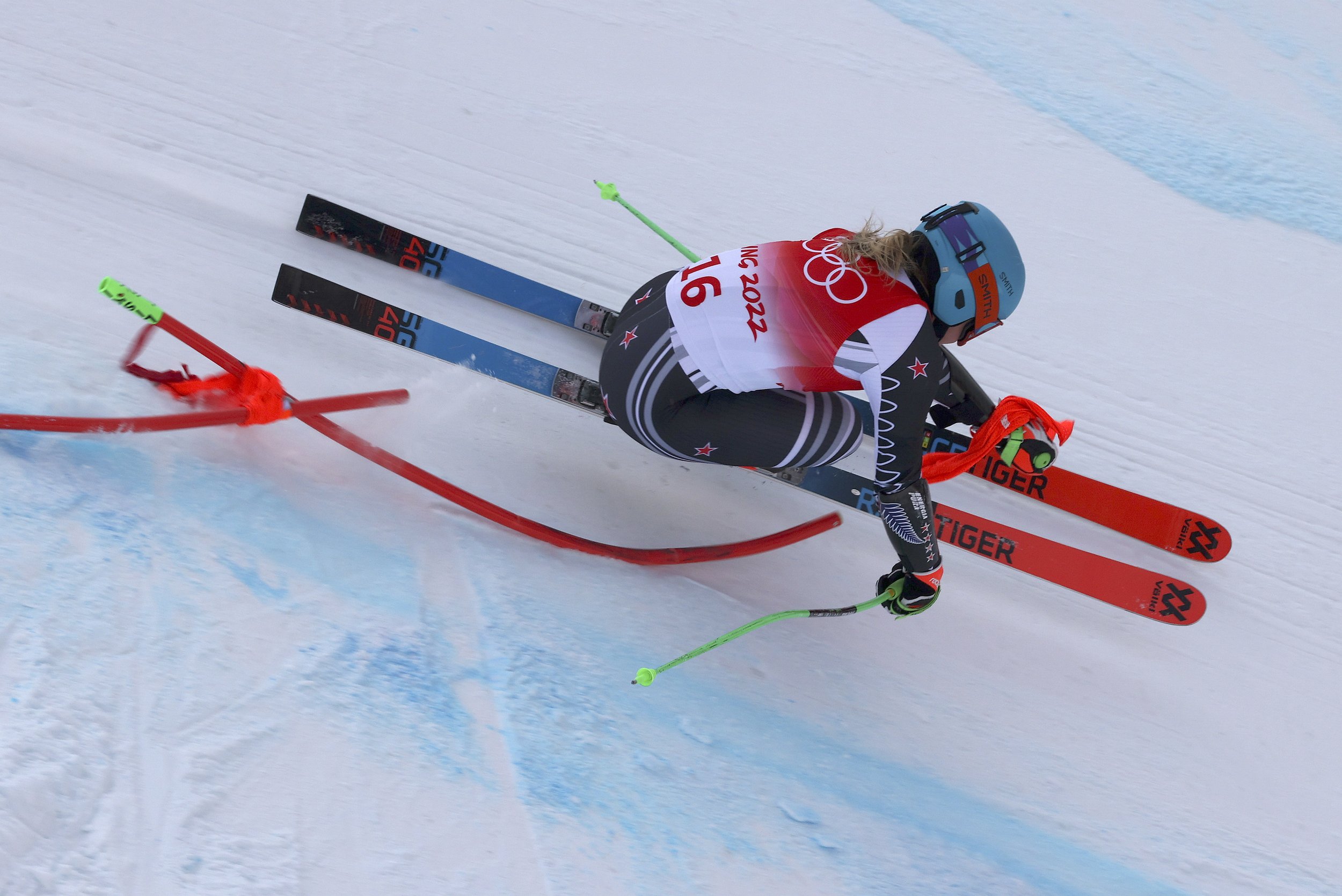  Alice Robinson, of New Zealand crashes into a flag during the women's super-G at the 2022 Winter Olympics, Friday, Feb. 11, 2022, in the Yanqing district of Beijing. (AP Photo/Alessandro Trovati) 