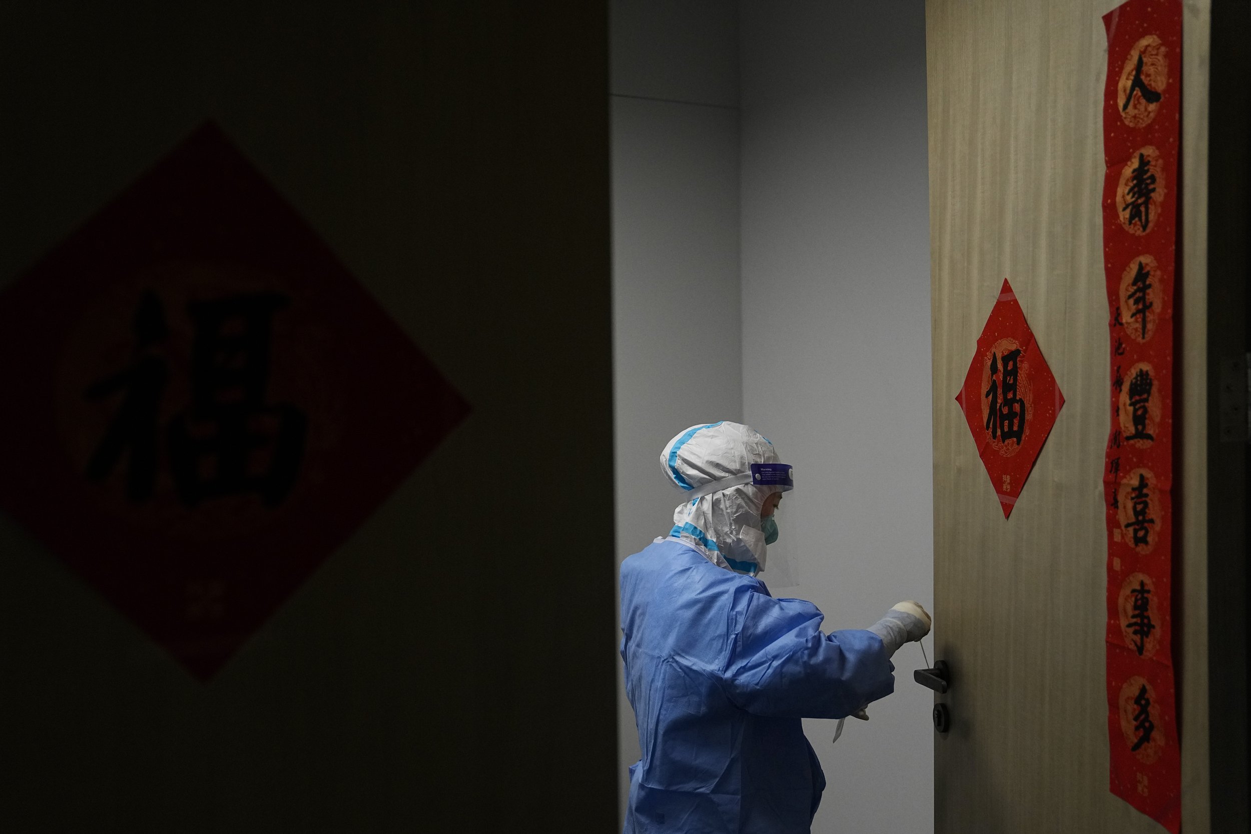  A medical worker collects a sample from a door knob of an office to test for COVID-19 in the main media center at the 2022 Winter Olympics, Friday, Feb. 11, 2022, in Beijing. (AP Photo/Jae C. Hong) 