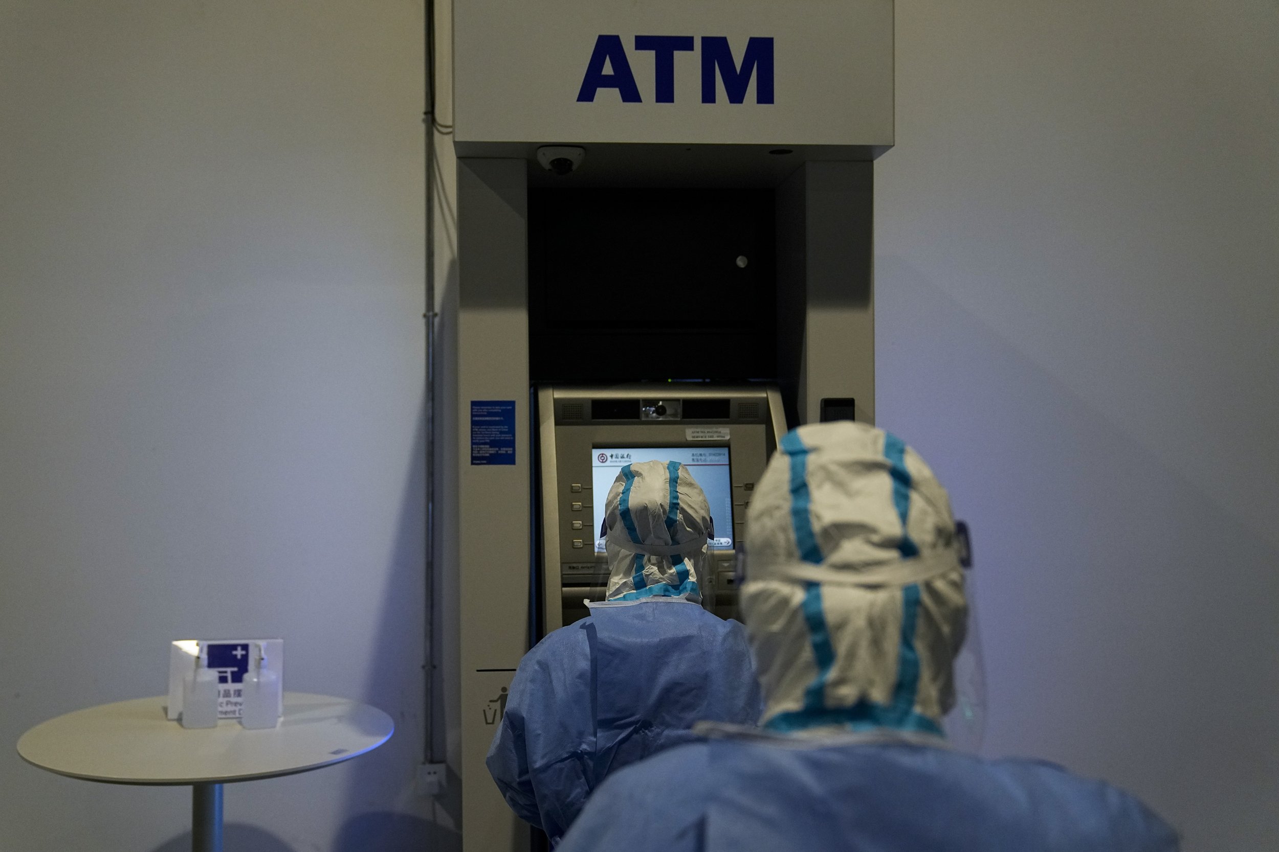  Two medical workers collect a sample from an ATM for COVID testing in the main media center at the 2022 Winter Olympics, Friday, Feb. 11, 2022, in Beijing. (AP Photo/Jae C. Hong) 