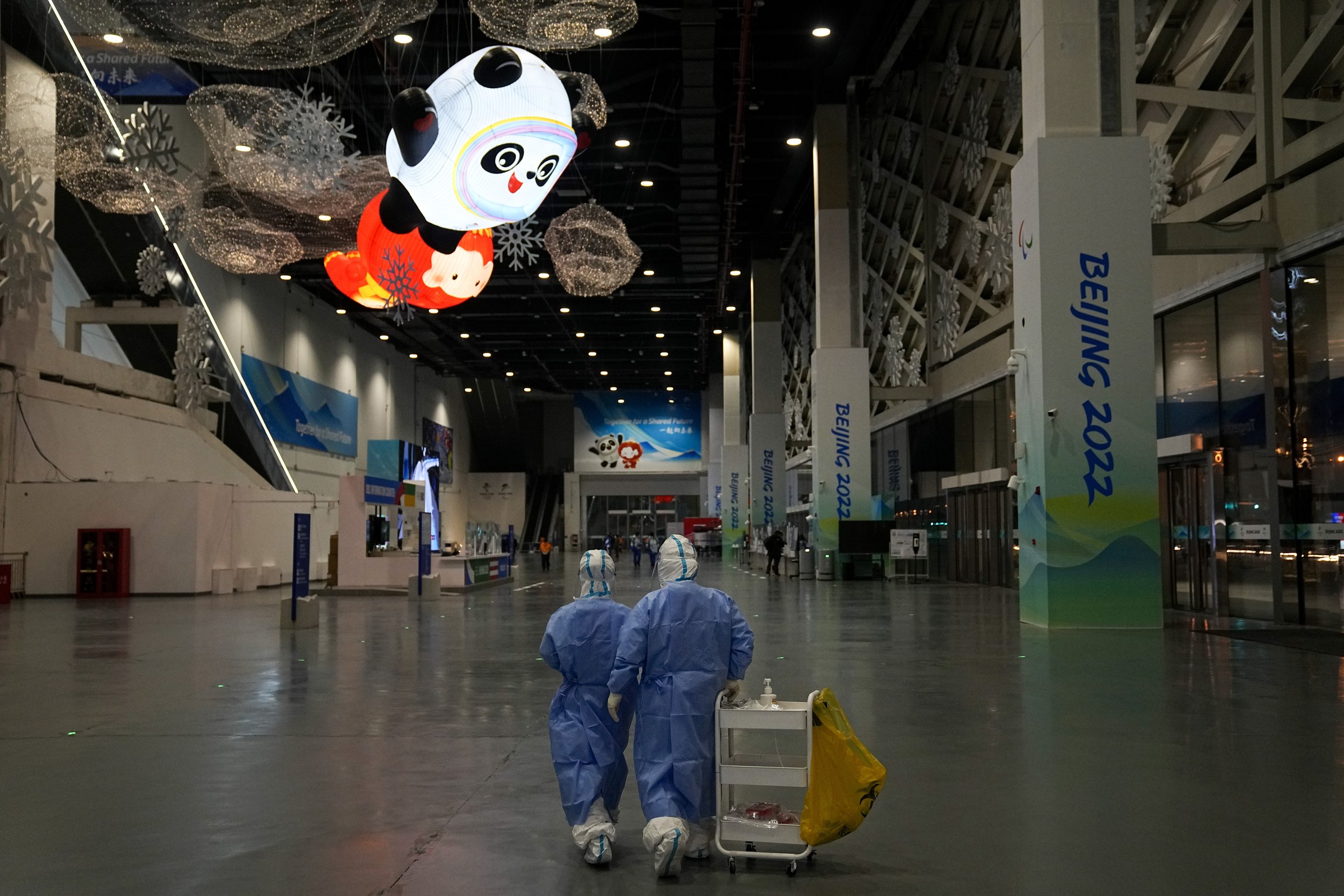  Two medical workers head back to their office after collecting dozens of samples for COVID testing in the main media center at the 2022 Winter Olympics, Friday, Feb. 11, 2022, in Beijing. (AP Photo/Jae C. Hong) 