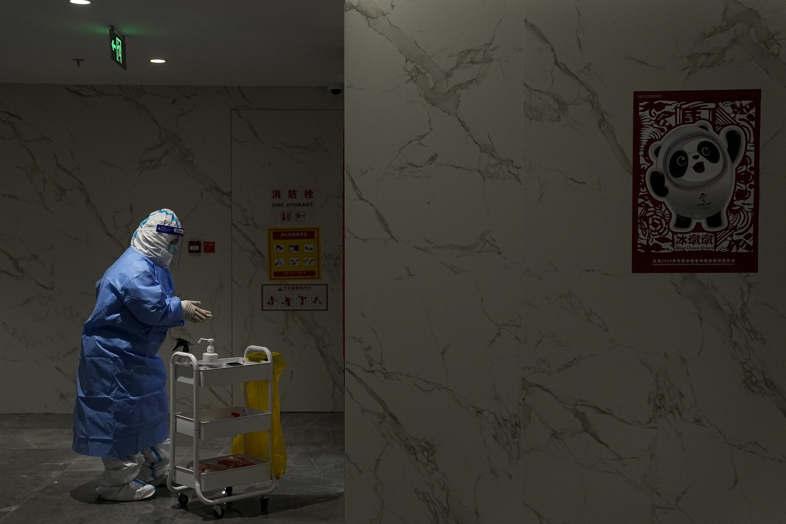  A medical worker disinfects her hands while collecting samples for COVID-19 testing in the main media center at the 2022 Winter Olympics, Friday, Feb. 11, 2022, in Beijing. (AP Photo/Jae C. Hong) 