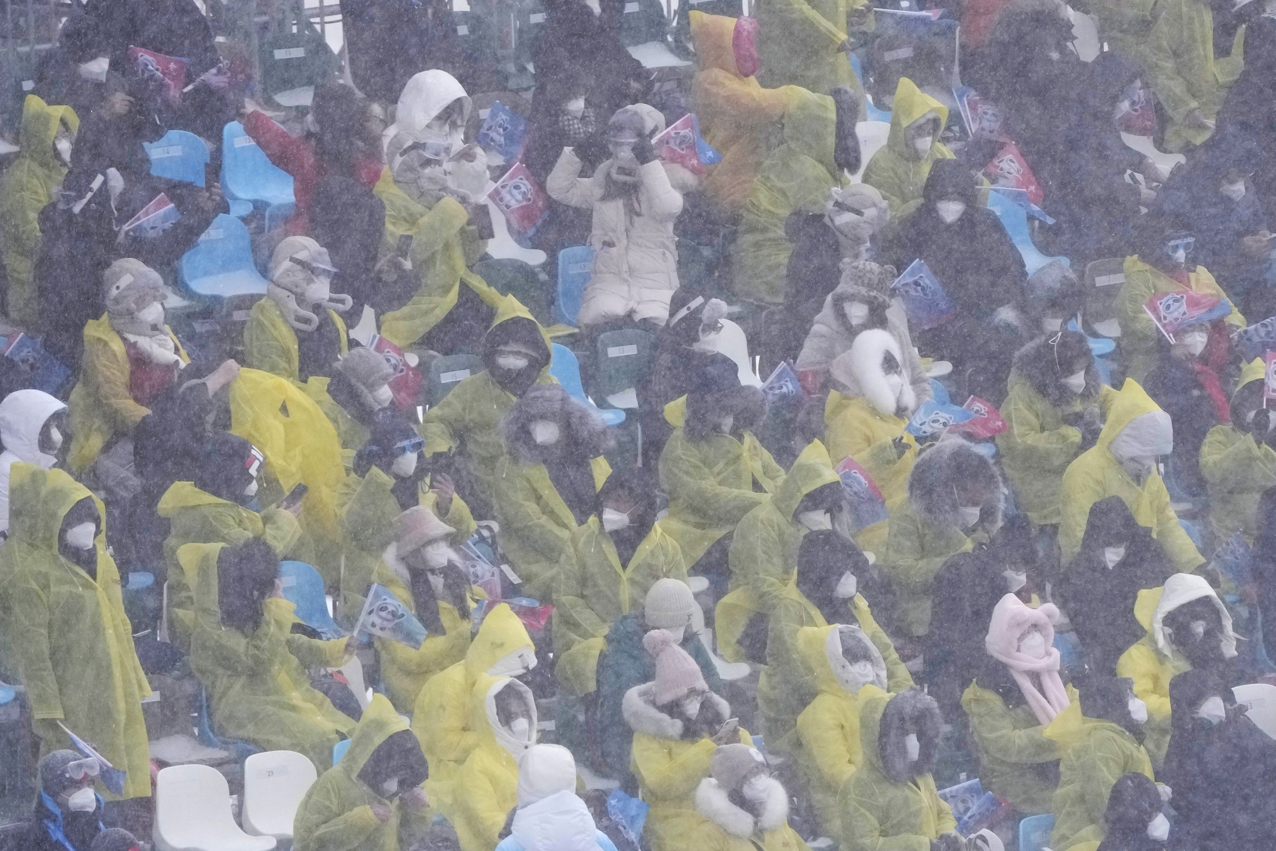  Spectators watch during the mixed team snowboard cross finals as the snow falls at the 2022 Winter Olympics, Saturday, Feb. 12, 2022, in Zhangjiakou, China. (AP Photo/Lee Jin-man) 
