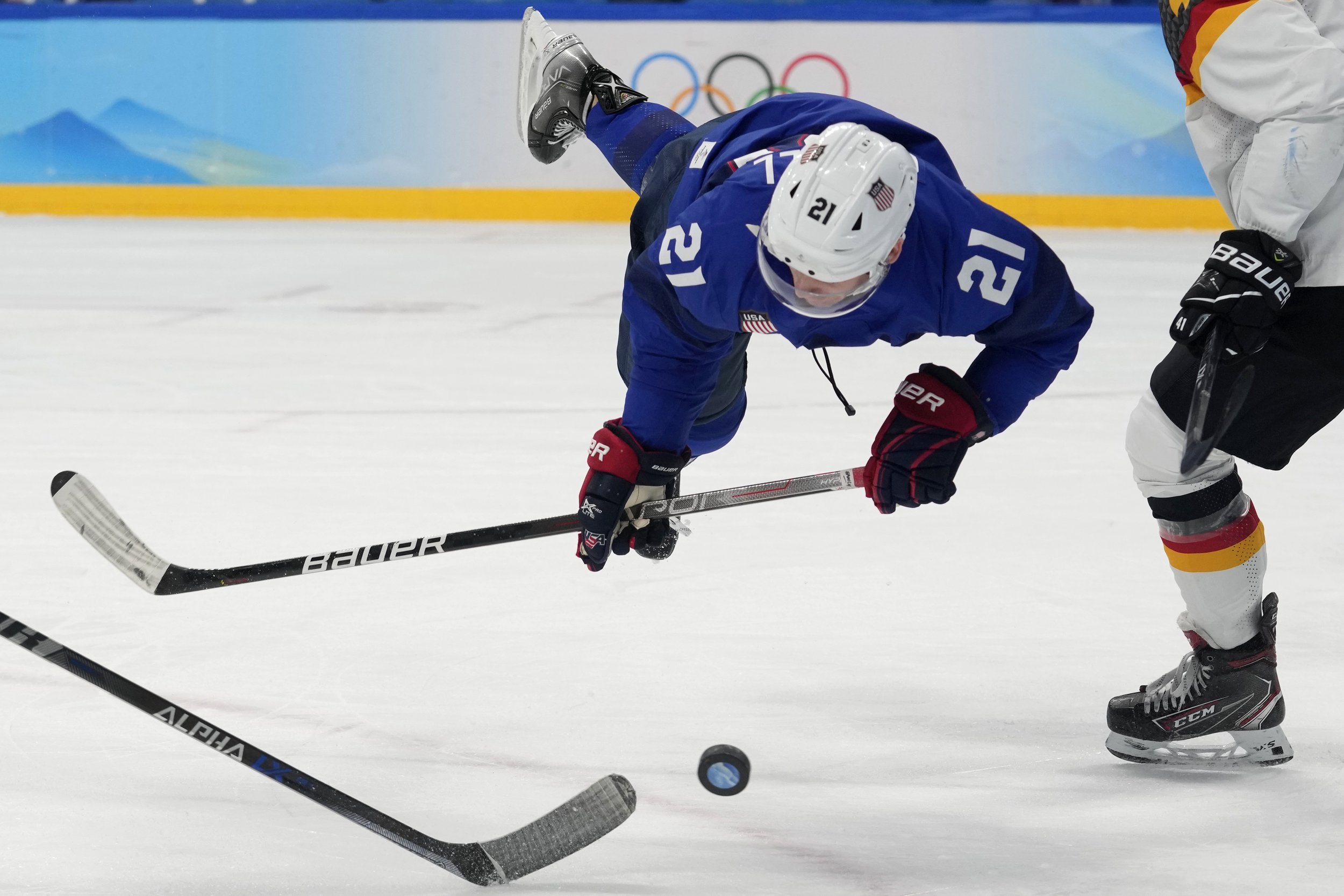  United States' Brian O'Neill falls as he goes for the puck during a preliminary round men's hockey game against Germany at the 2022 Winter Olympics, Sunday, Feb. 13, 2022, in Beijing. (AP Photo/Petr David Josek) 