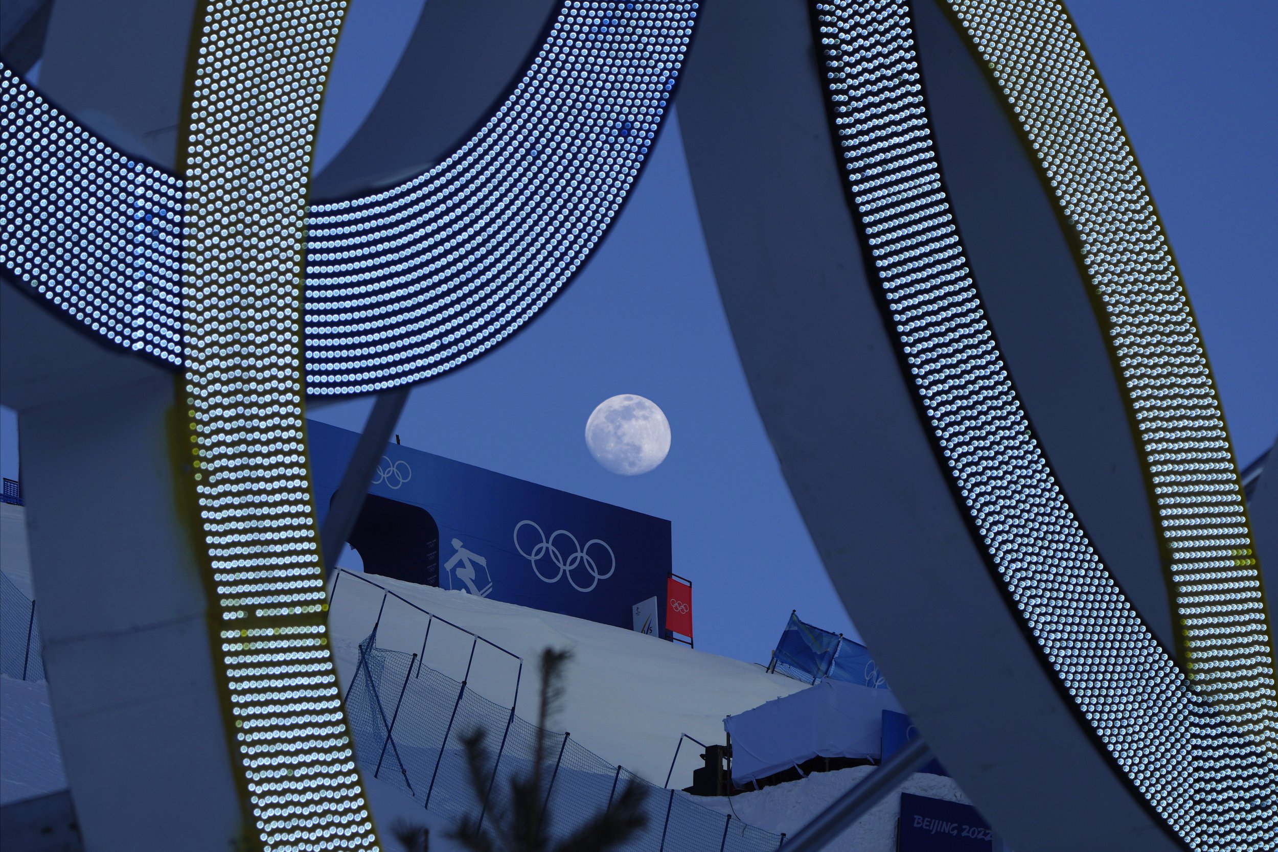  The moon rises over Genting Snow Park before the women's freestyle skiing aerials finals at the 2022 Winter Olympics, Monday, Feb. 14, 2022, in Zhangjiakou, China. (AP Photo/Kiichiro Sato) 