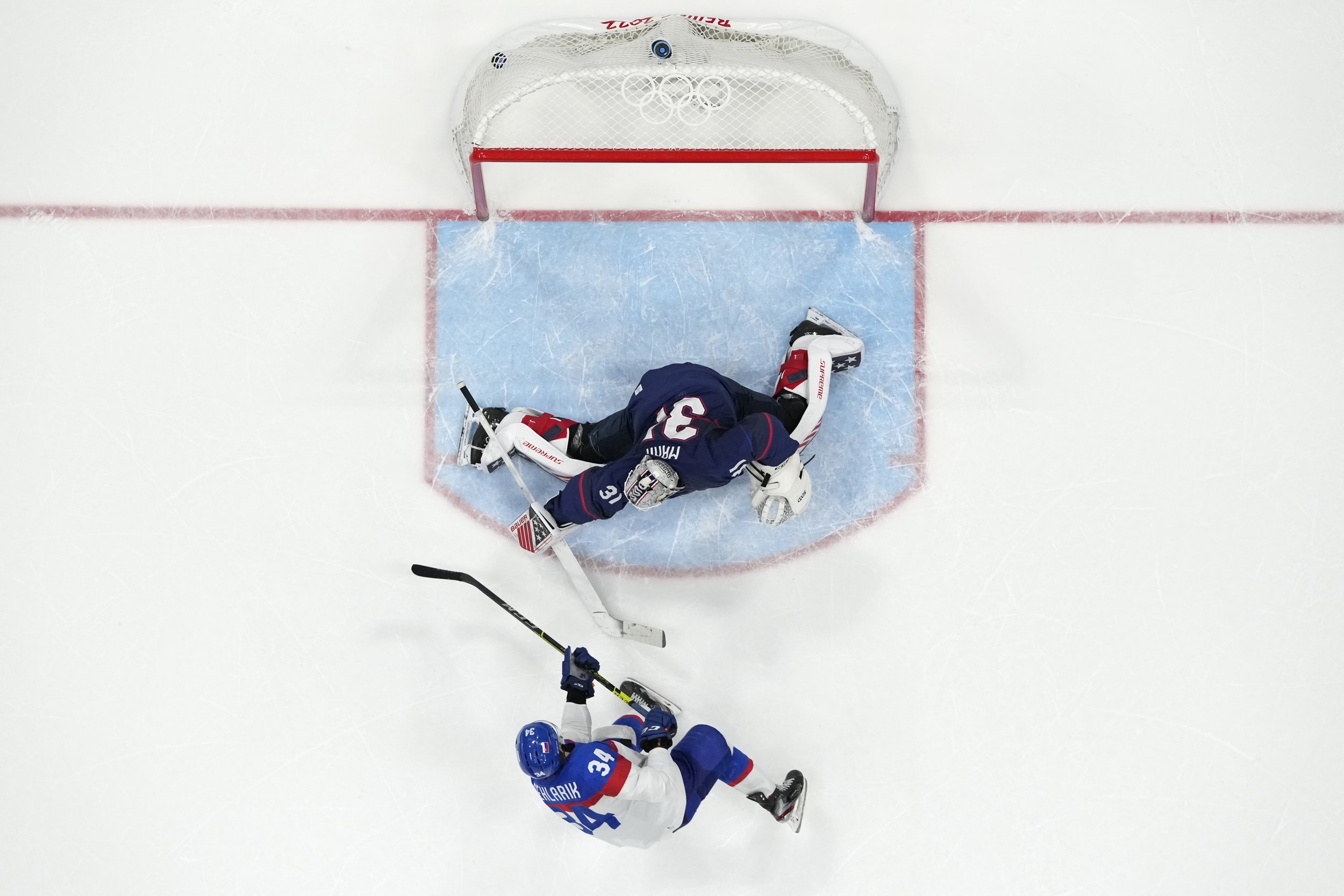  Slovakia's Peter Cehlarik (34) scores the winning goal past United States goalkeeper Strauss Mann (31) during a shoot-out in a men's quarterfinal hockey game at the 2022 Winter Olympics, Wednesday, Feb. 16, 2022, in Beijing. Slovakia won 3-2. (AP Ph