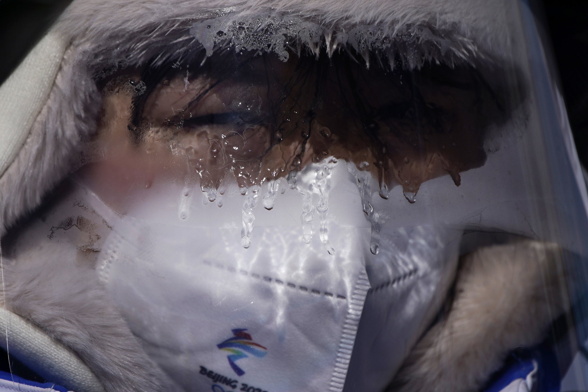  Ice forms on the face shield of a volunteer during a cross-country skiing practice before the 2022 Winter Olympics, Wednesday, Feb. 2, 2022, in Zhangjiakou, China. (AP Photo/John Locher) 