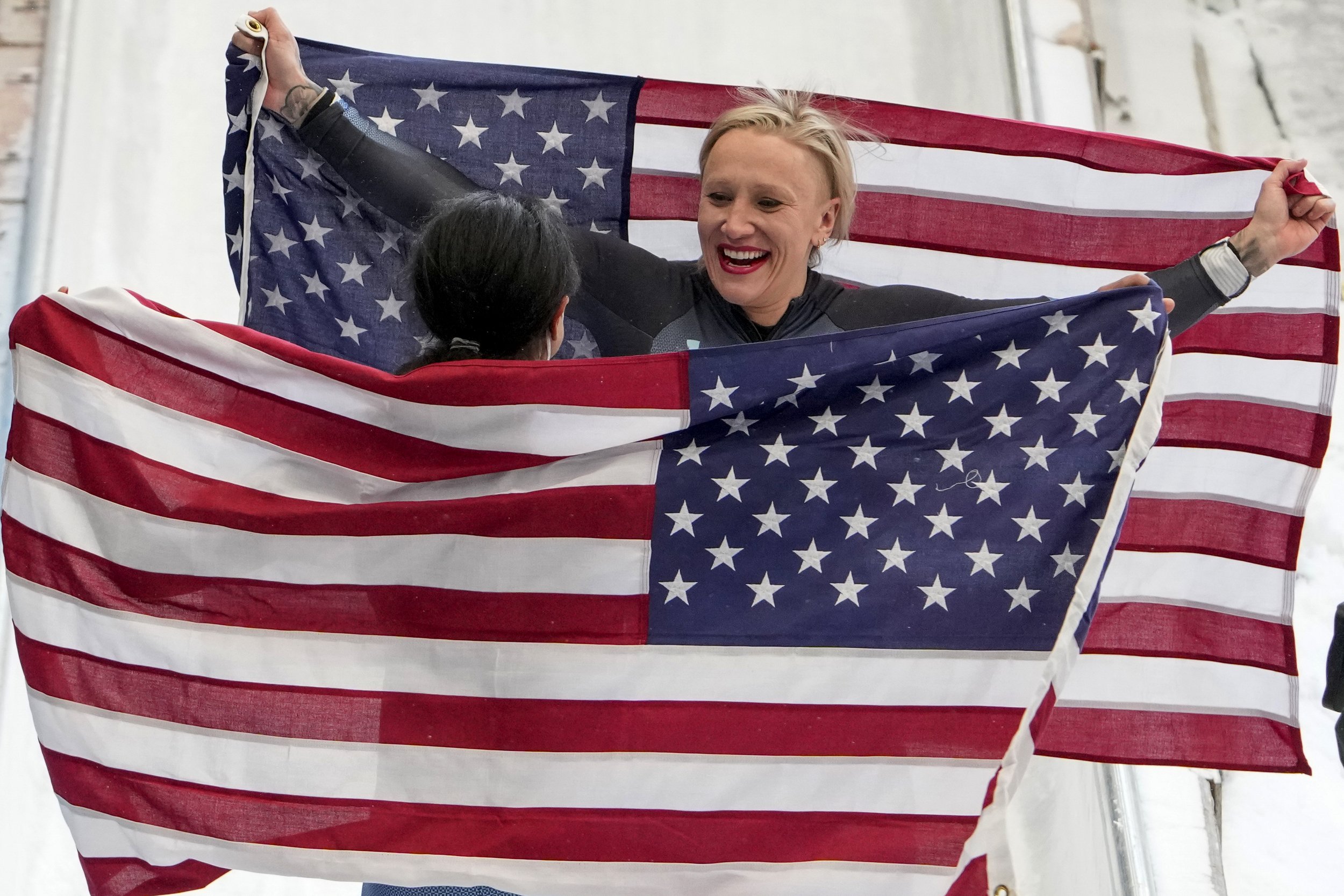  Kaillie Humphries, of the United States, center, and teammate Elana Meyers Taylor celebrate winning the gold and silver medals in the women's monobob at the 2022 Winter Olympics, Monday, Feb. 14, 2022, in the Yanqing district of Beijing. (AP Photo/P