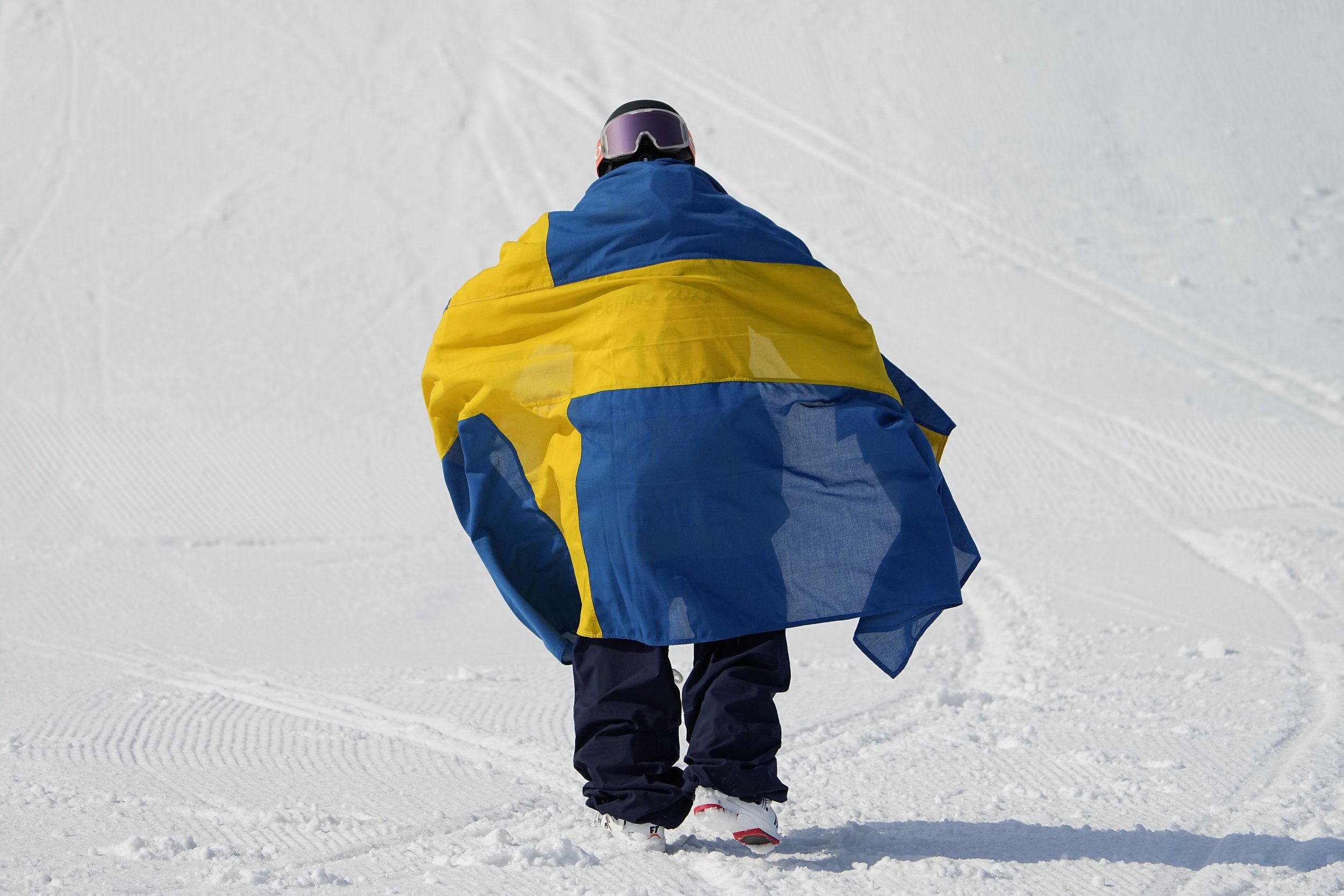  Bronze medal winner Henrik Harlaut of Sweden walks with his country's flag after the men's freestyle skiing big air finals of the 2022 Winter Olympics, Wednesday, Feb. 9, 2022, in Beijing. (AP Photo/Jae C. Hong) 