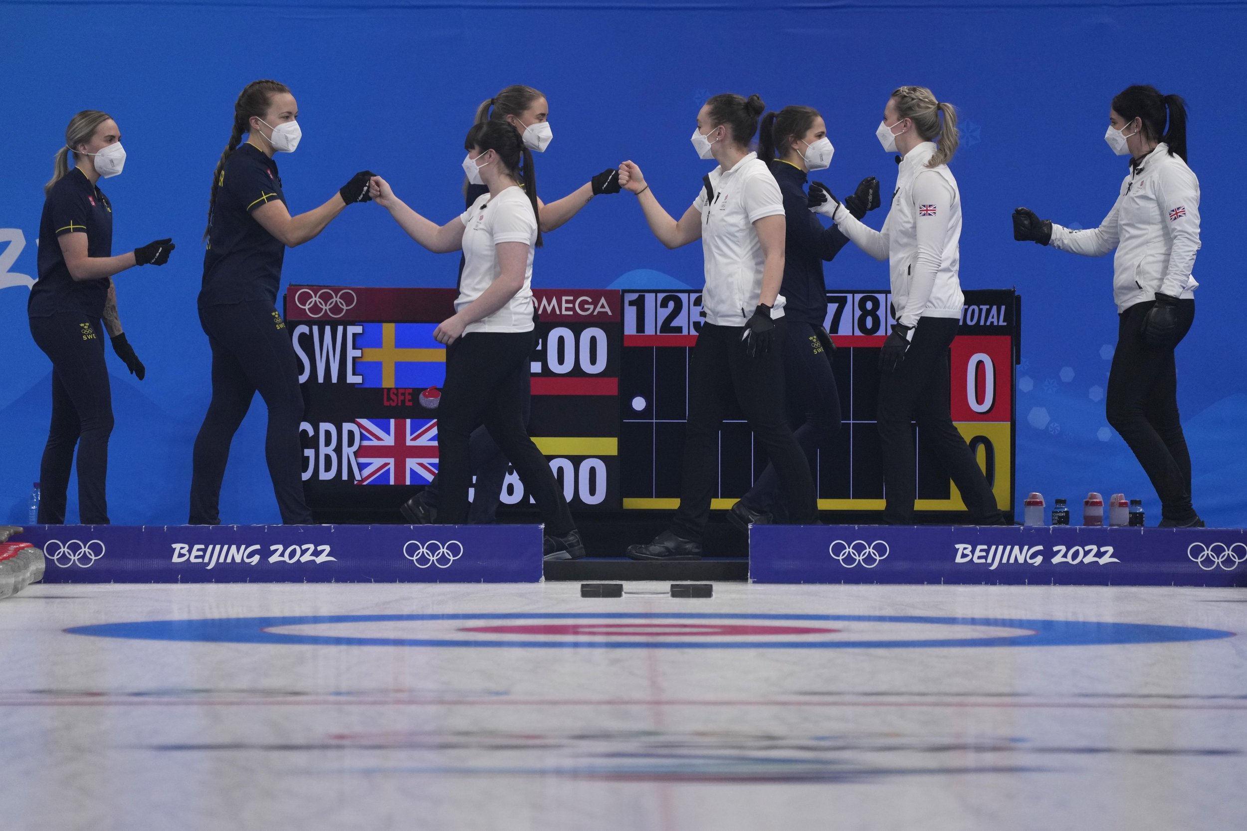  Team Sweden, in blue, and Britain greet each other before the start of the women's curling semifinal match between Britain and Sweden at the Beijing Winter Olympics Friday, Feb. 18, 2022, in Beijing. (AP Photo/Nariman El-Mofty) 