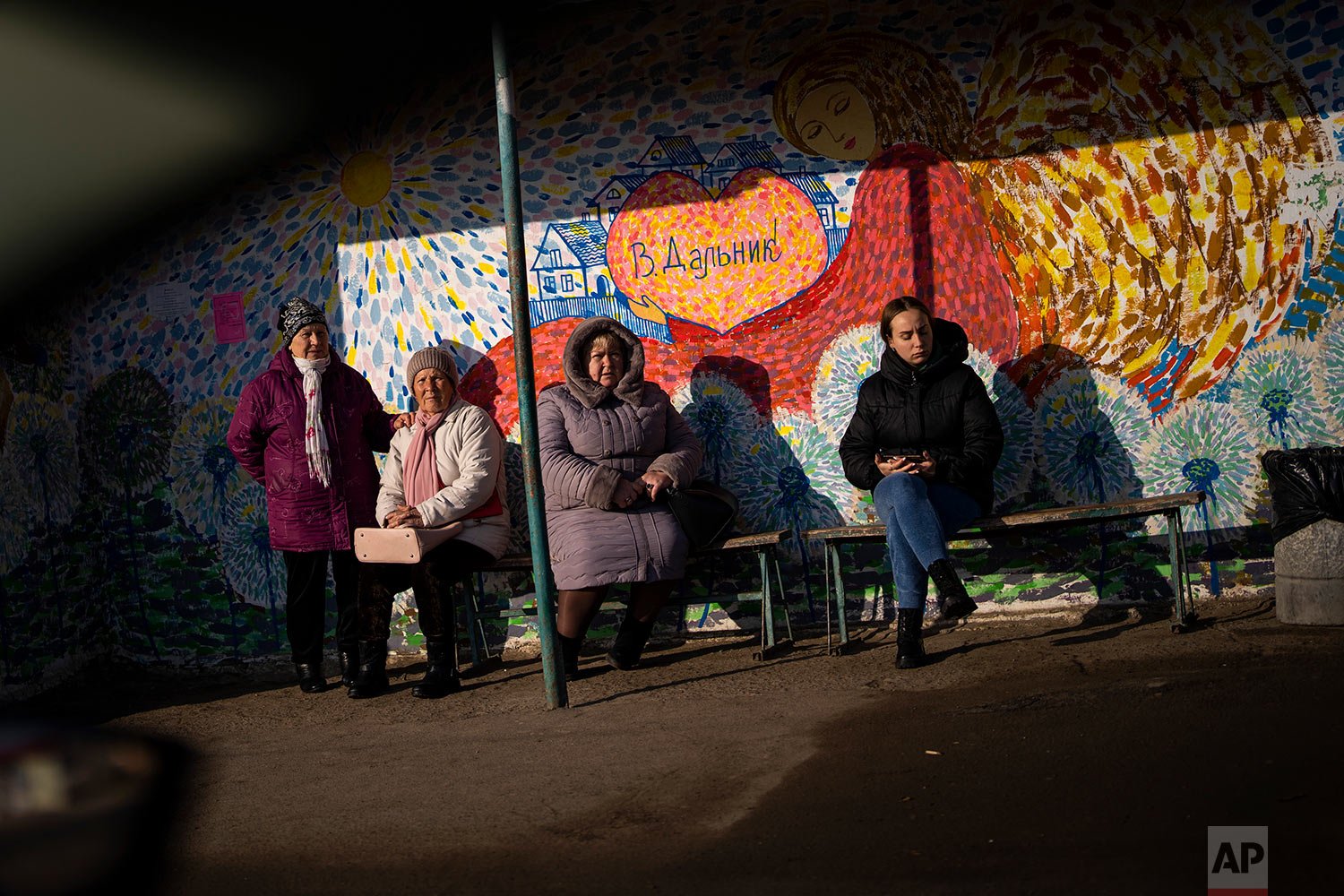  Women wait at a bus stop in Odessa, Ukraine, Thursday, Feb. 17, 2022. (AP Photo/Emilio Morenatti) 