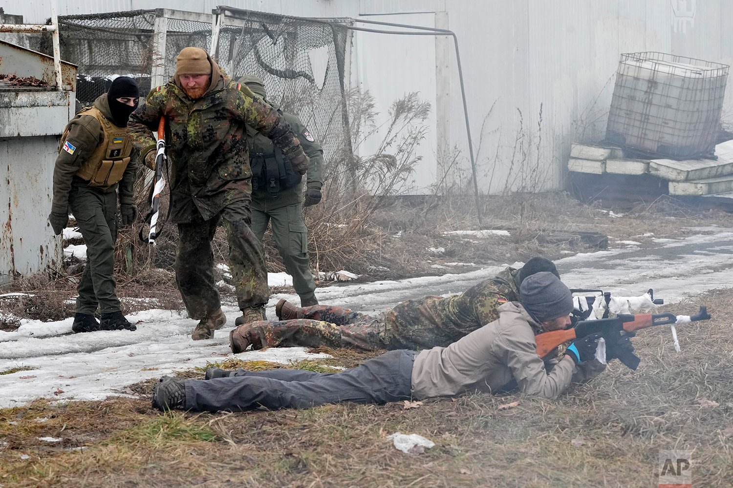  An instructor, second left, runs during a training for civilians and members of the Georgian Legion, a paramilitary unit formed mainly by ethnic Georgian volunteers to fight against Russian forces in Ukraine in 2014, in Kyiv, Ukraine, Saturday, Feb.