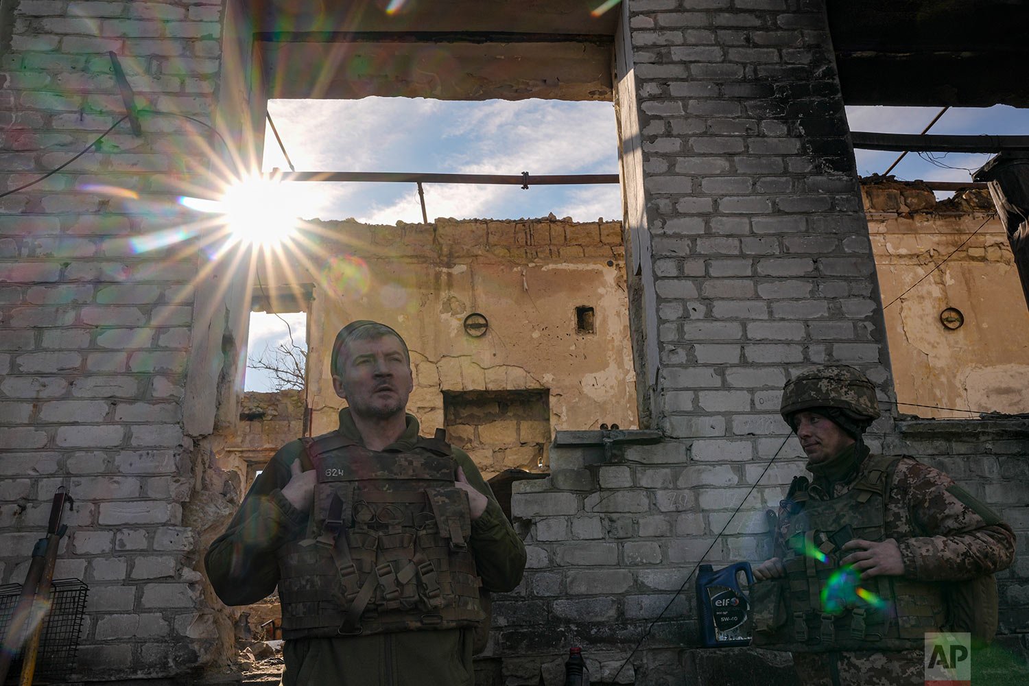  Ukrainian servicemen stand by a destroyed house near the frontline village of Krymske, Luhansk region, in eastern Ukraine, Saturday, Feb. 19, 2022. (AP Photo/Vadim Ghirda) 