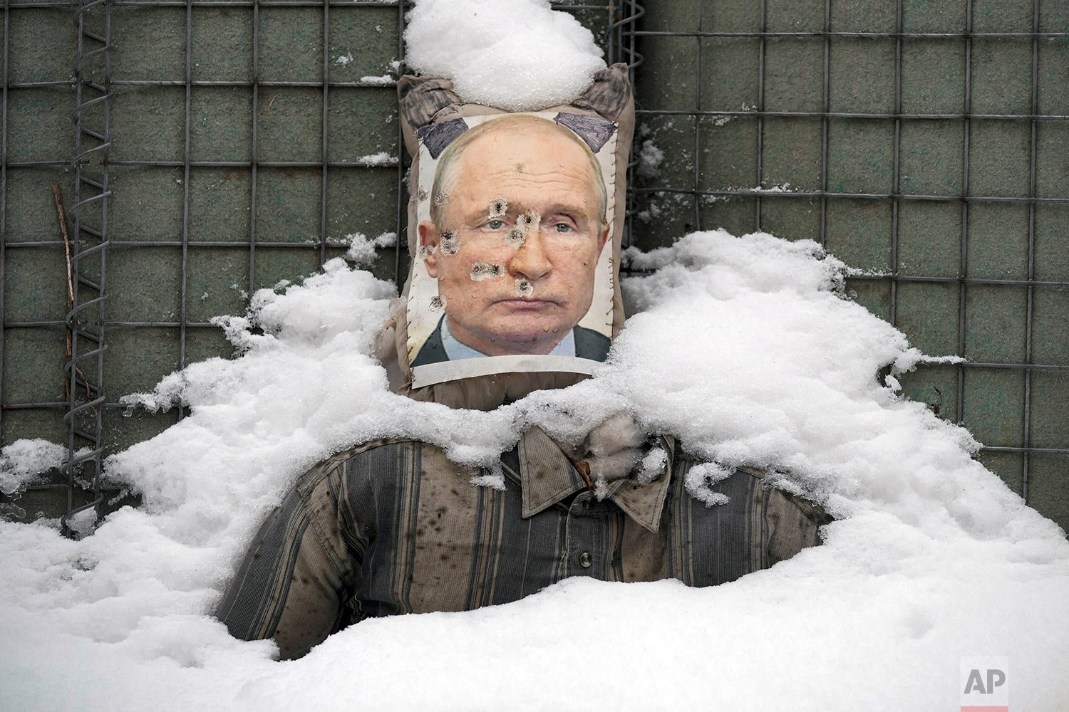  A bullet riddled effigy of Russian President Vladimir Putin, is coated by fresh snow at a frontline position in the Luhansk region, eastern Ukraine, Tuesday, Feb. 1, 2022. (AP Photo/Vadim Ghirda) 