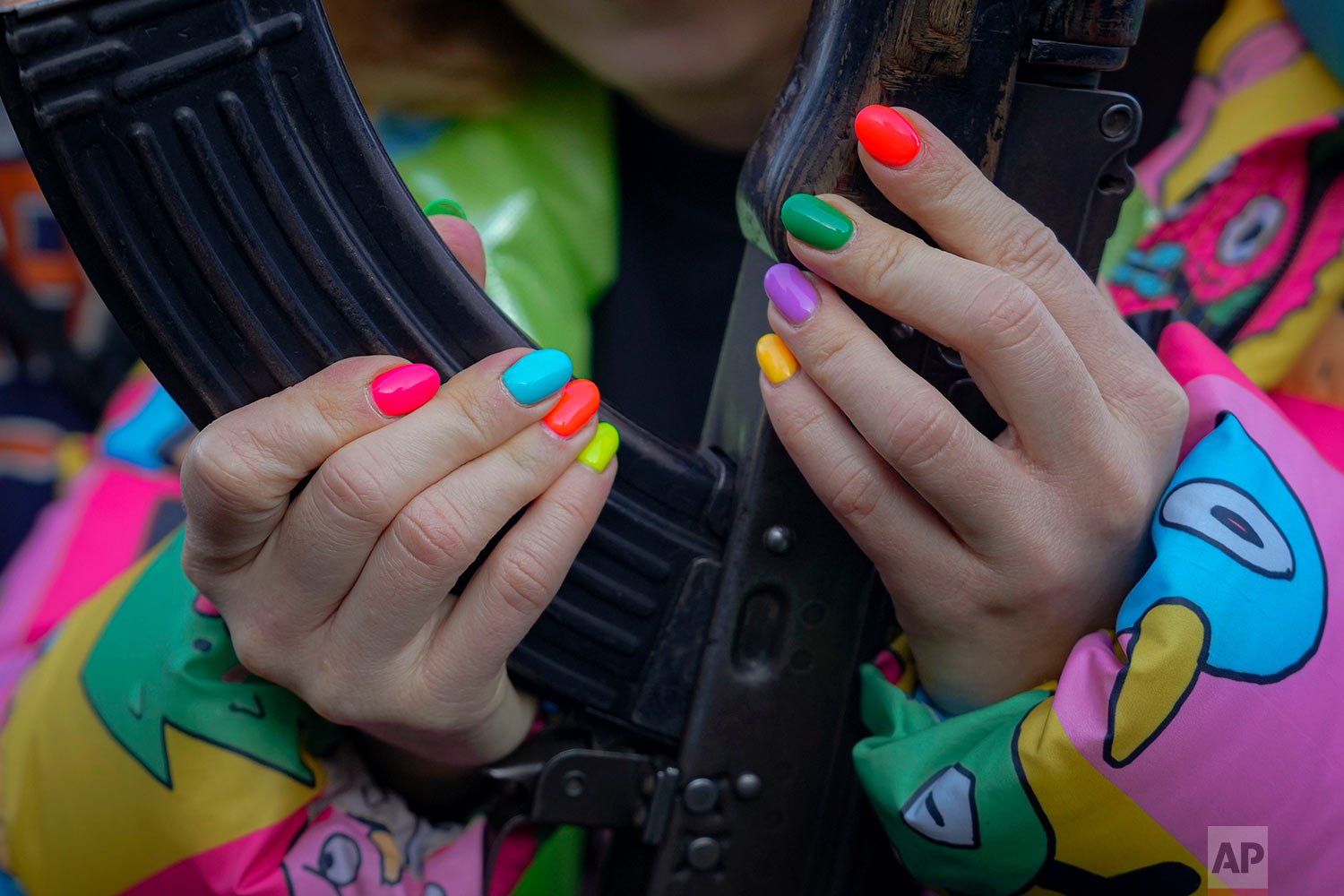  A young woman handles a weapon during a basic combat training for civilians, organized by the Special Forces Unit Azov, of Ukraine's National Guard, in Mariupol, Donetsk region, eastern Ukraine, Sunday, Feb. 13, 2022. (AP Photo/Vadim Ghirda) 