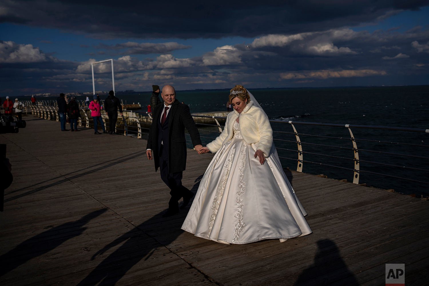  Newlyweds Alexandra Tabashnenko, 27 and Pavel Tabashnenko, 33 walk on a promenade after getting married in Odessa, Ukraine, Friday, Feb. 18, 2022. (AP Photo/Emilio Morenatti) 