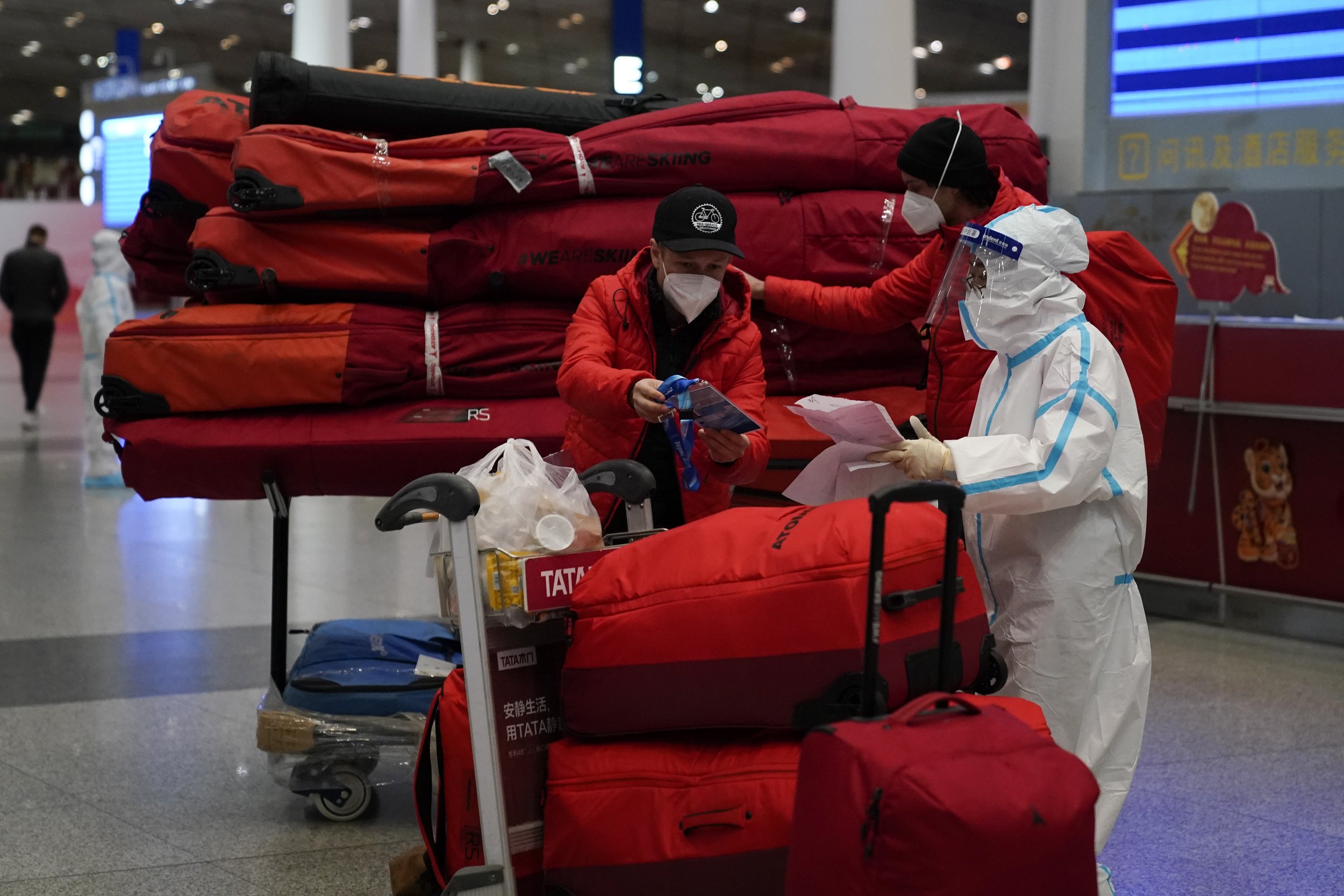  Passengers check their bags at the Beijing Capital International Airport after the conclusion of the 2022 Winter Olympics, Sunday, Feb. 20, 2022, in Beijing. (AP Photo/Ashley Landis) 