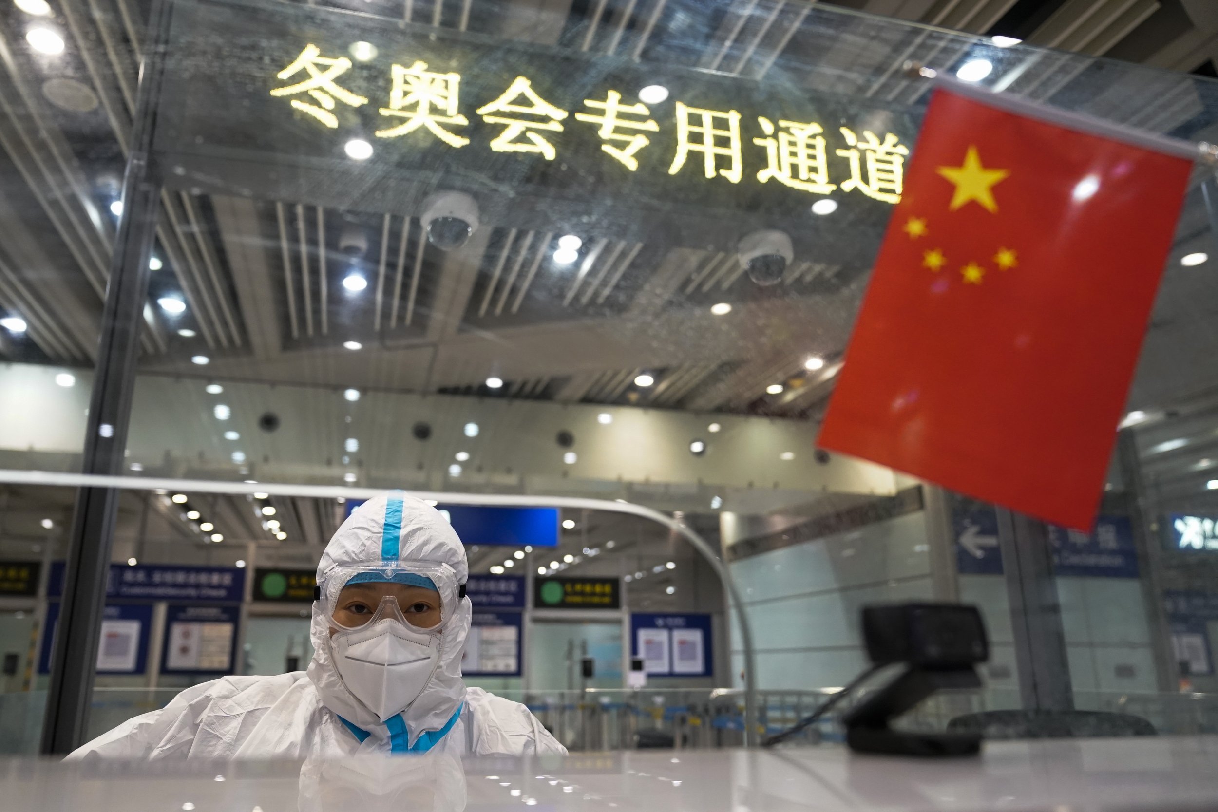  A customs worker checks forms at the Beijing Capital International Airport after the conclusion of the 2022 Winter Olympics, Sunday, Feb. 20, 2022, in Beijing. (AP Photo/Ashley Landis) 