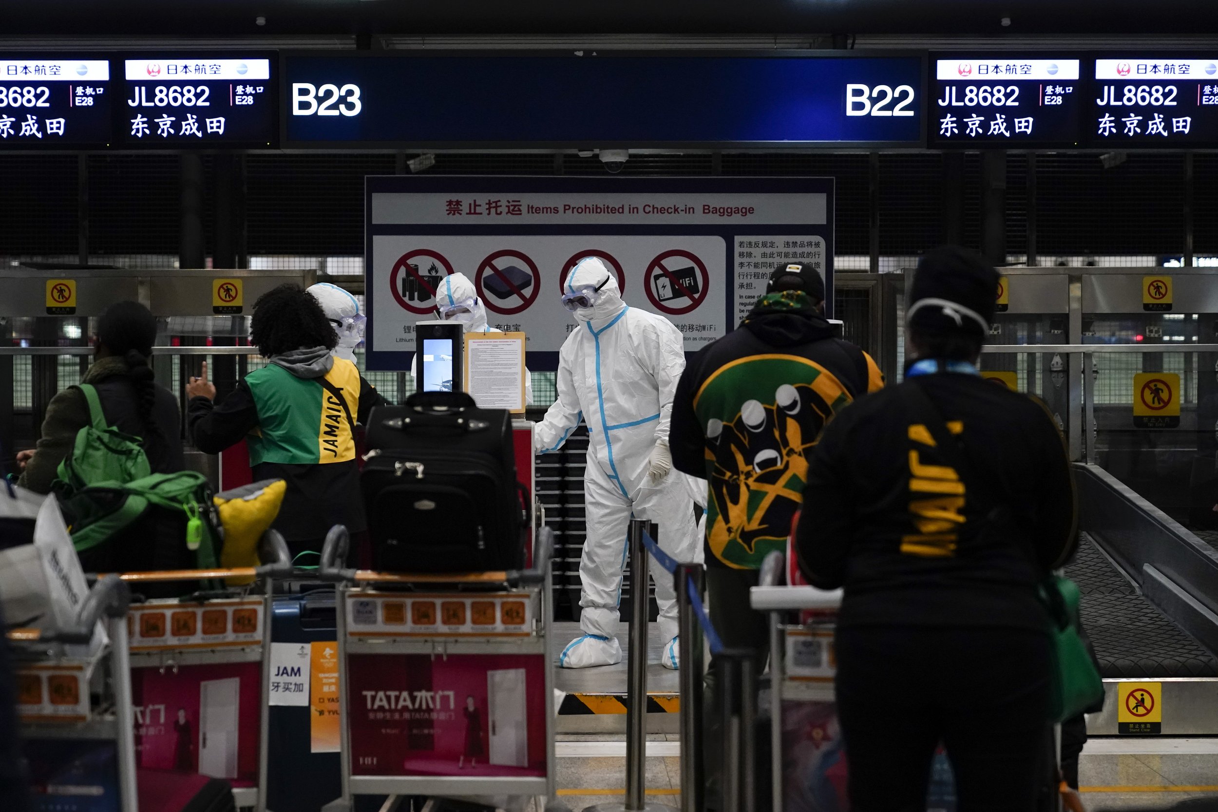  Jamaican passengers line up to check in for their flights at Beijing Capital International Airport after the conclusion of the 2022 Winter Olympics, Sunday, Feb. 20, 2022, in Beijing. (AP Photo/Ashley Landis) 