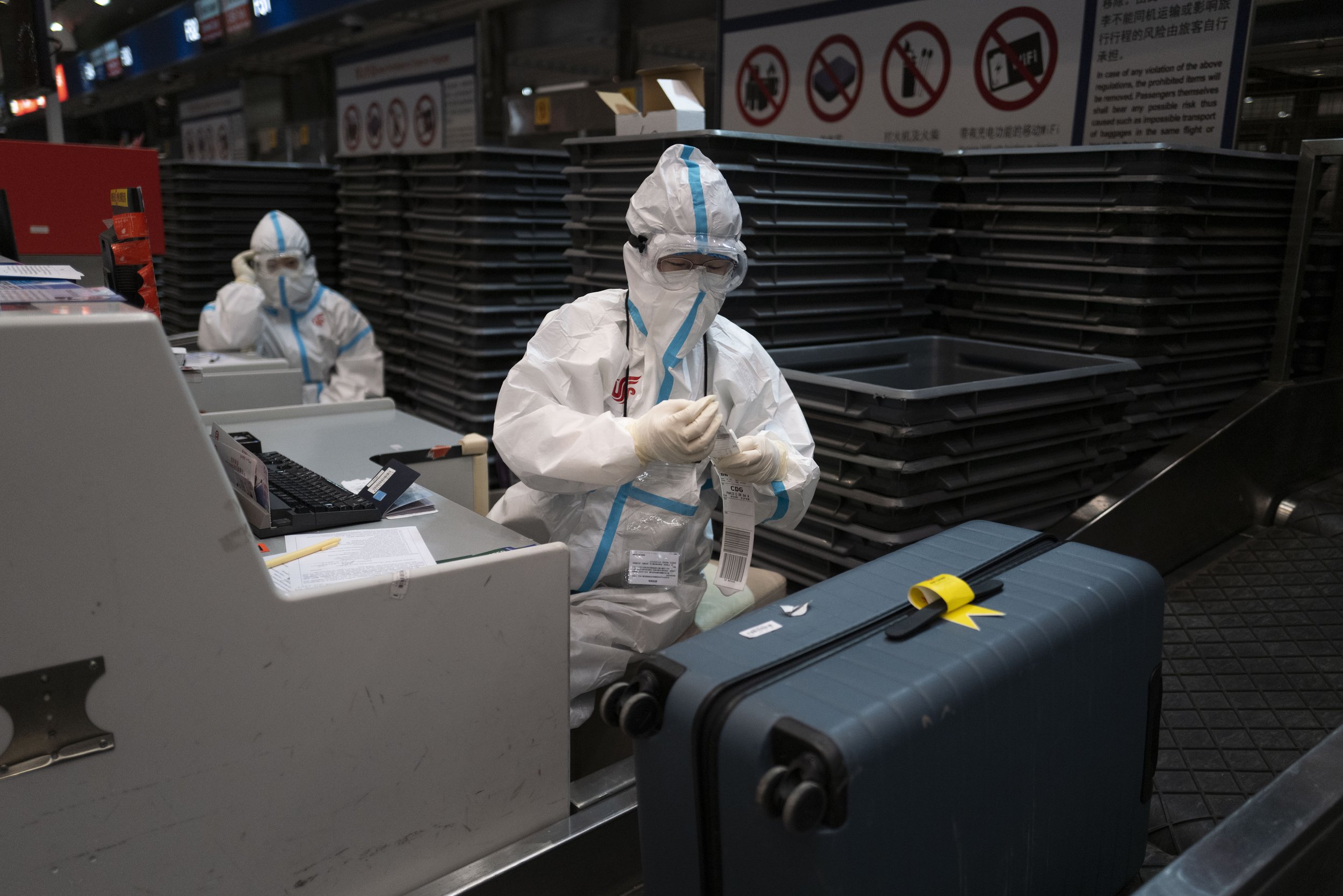  An airport employee in protective gear works at the Beijing Capital International Airport after the 2022 Winter Olympics, Monday, Feb. 21, 2022, in Beijing. (AP Photo/Jae C. Hong) 