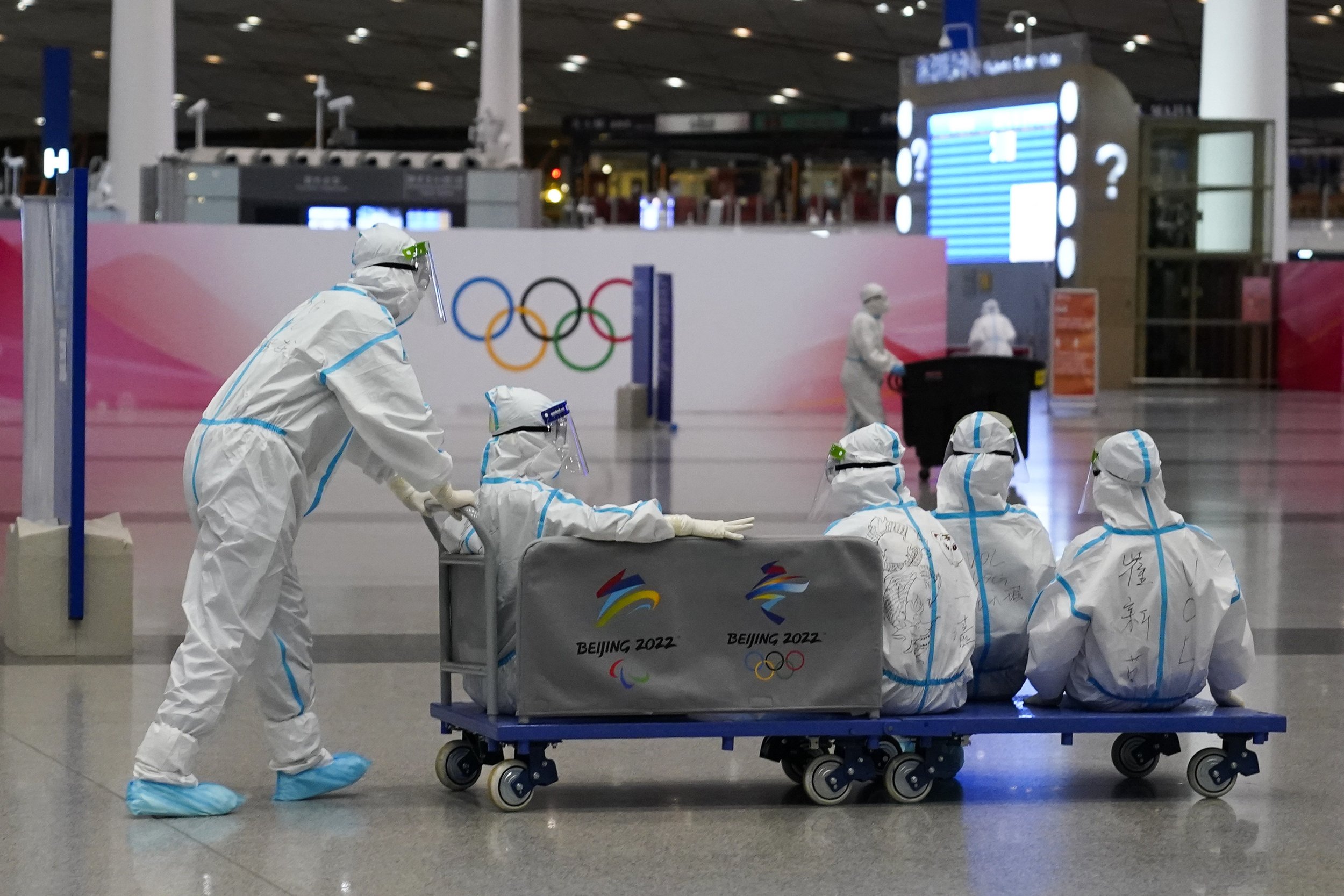  Volunteers ride on a cart at the Beijing Capital International Airport after the conclusion of the 2022 Winter Olympics, Sunday, Feb. 20, 2022, in Beijing. (AP Photo/Ashley Landis) 
