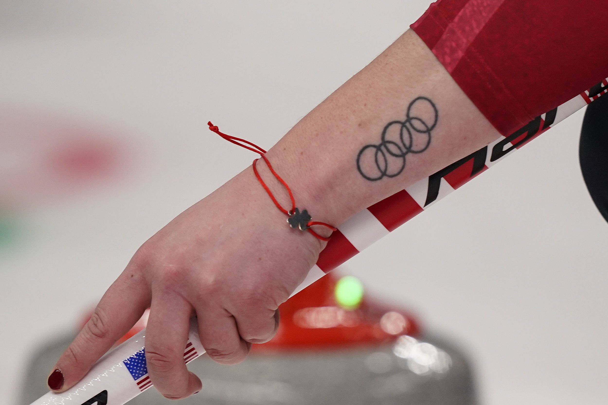  United States' Rebecca Hamilton holds a curling broom with a tattoo of the Olympics Rings during a women's curling match against the Russian Olympic Committee at the Beijing Winter Olympics Monday, Feb. 14, 2022, in Beijing. (AP Photo/Brynn Anderson