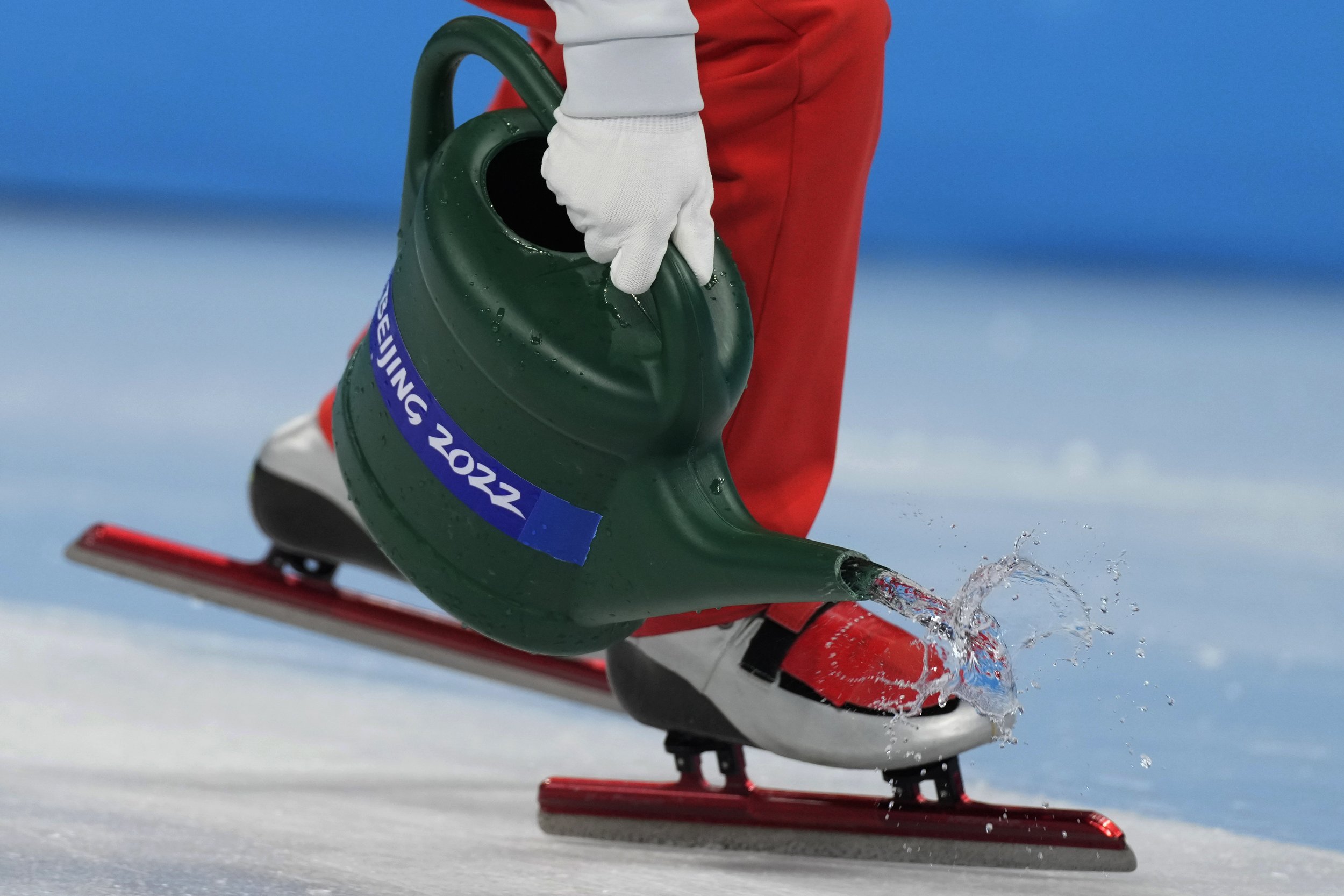  Track officials pour water on the track during the short track speedskating competition at the 2022 Winter Olympics, Wednesday, Feb. 9, 2022, in Beijing. (AP Photo/Natacha Pisarenko) 