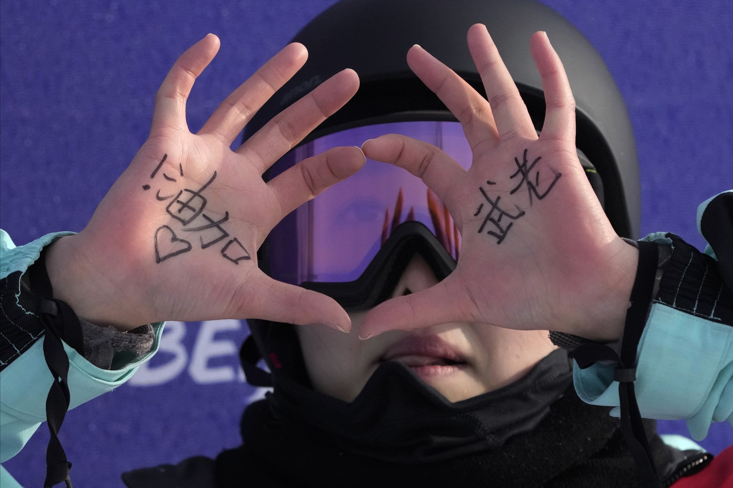  China's Qiu Leng holds up her hands with words of encouragement during the women's halfpipe finals at the 2022 Winter Olympics, Thursday, Feb. 10, 2022, in Zhangjiakou, China. (AP Photo/Lee Jin-man) 