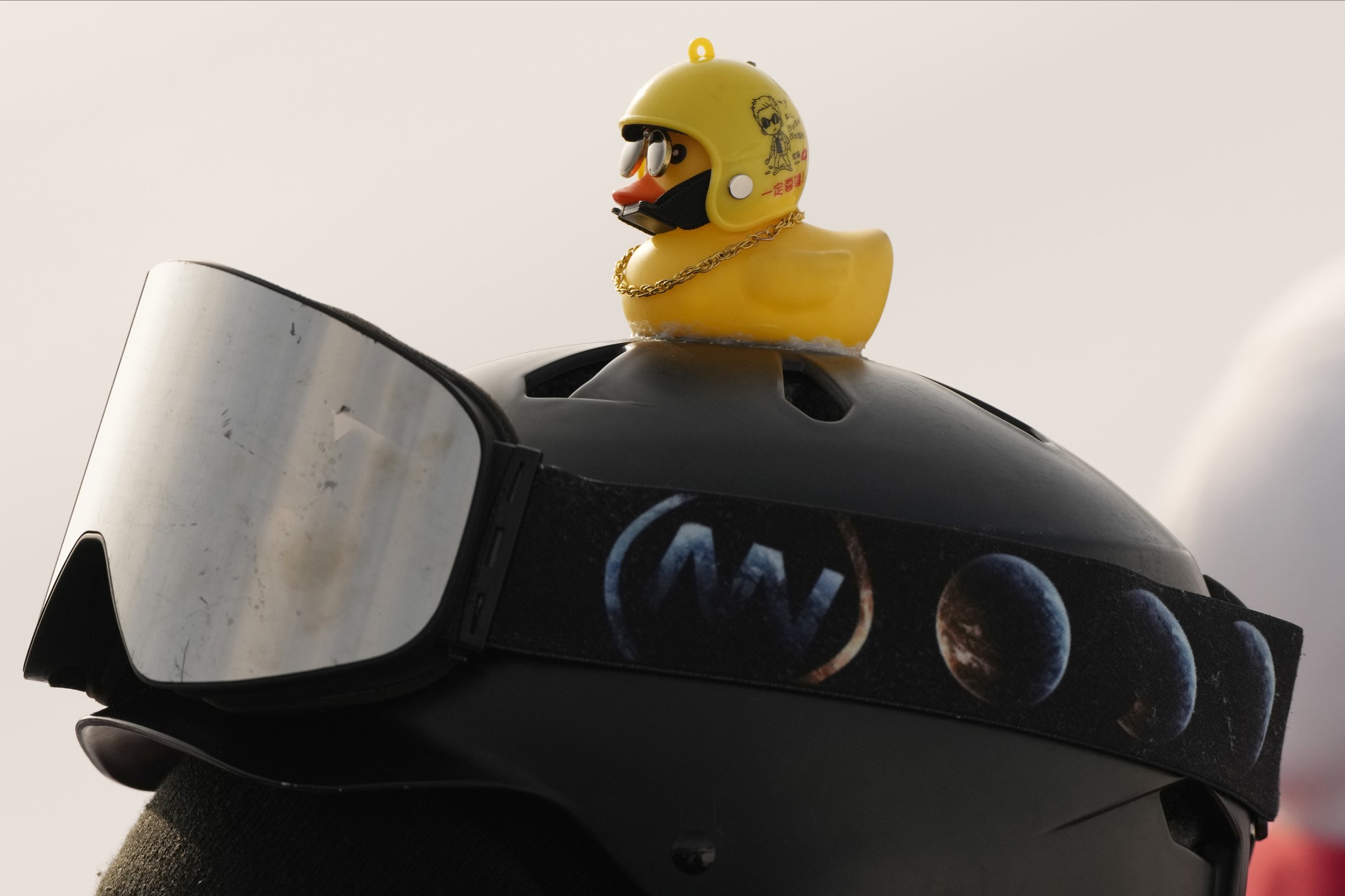  A volunteer fashions a rubber duck on the top of his helmet during the women's halfpipe finals at the 2022 Winter Olympics, Thursday, Feb. 10, 2022, in Zhangjiakou, China. (AP Photo/Francisco Seco) 
