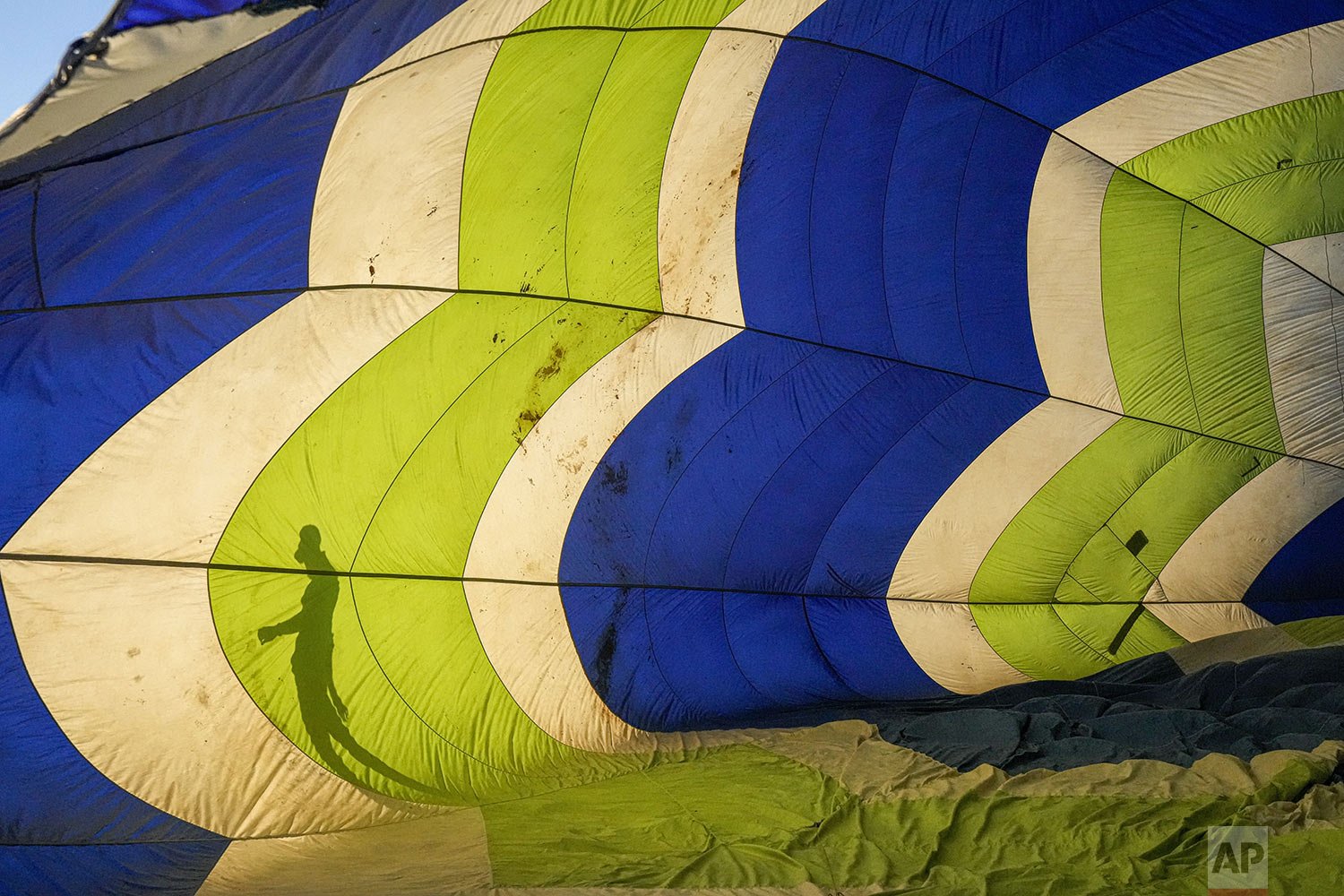  The shadow of a crew member is cast on a hot air balloon during the Cumbres Balloon Festival at El Trapiche Park on the outskirts of Santiago, Chile, Feb. 5, 2022. (AP Photo/Esteban Felix) 