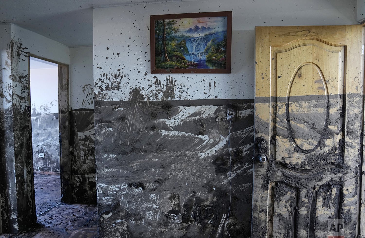  A line on a wall marks the level at which mud reached inside a home a day after a rain-weakened hillside collapsed and brought waves of mud over homes and a sports field in the La Gasca neighborhood of Quito, Ecuador, Feb. 2, 2022. (AP Photo/Dolores
