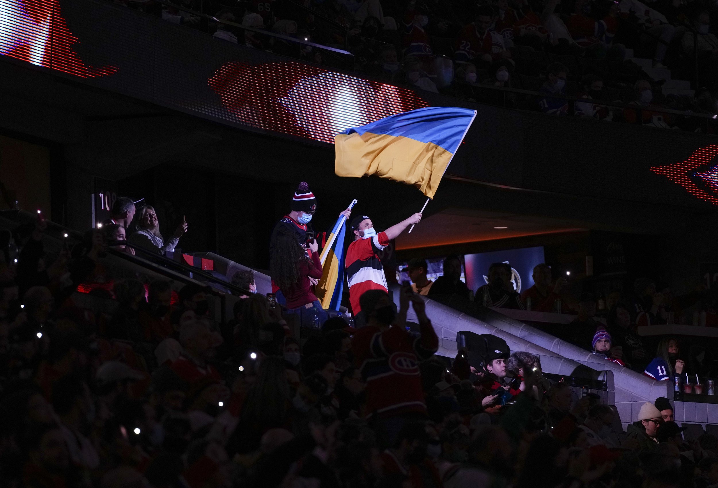  A fan waves the flag of Ukraine during the first intermission of an NHL hockey game between the Ottawa Senators and the Montreal Canadiens on Saturday, Feb. 26, 2022 in Ottawa, Ontario. (Justin Tang/The Canadian Press via AP) 