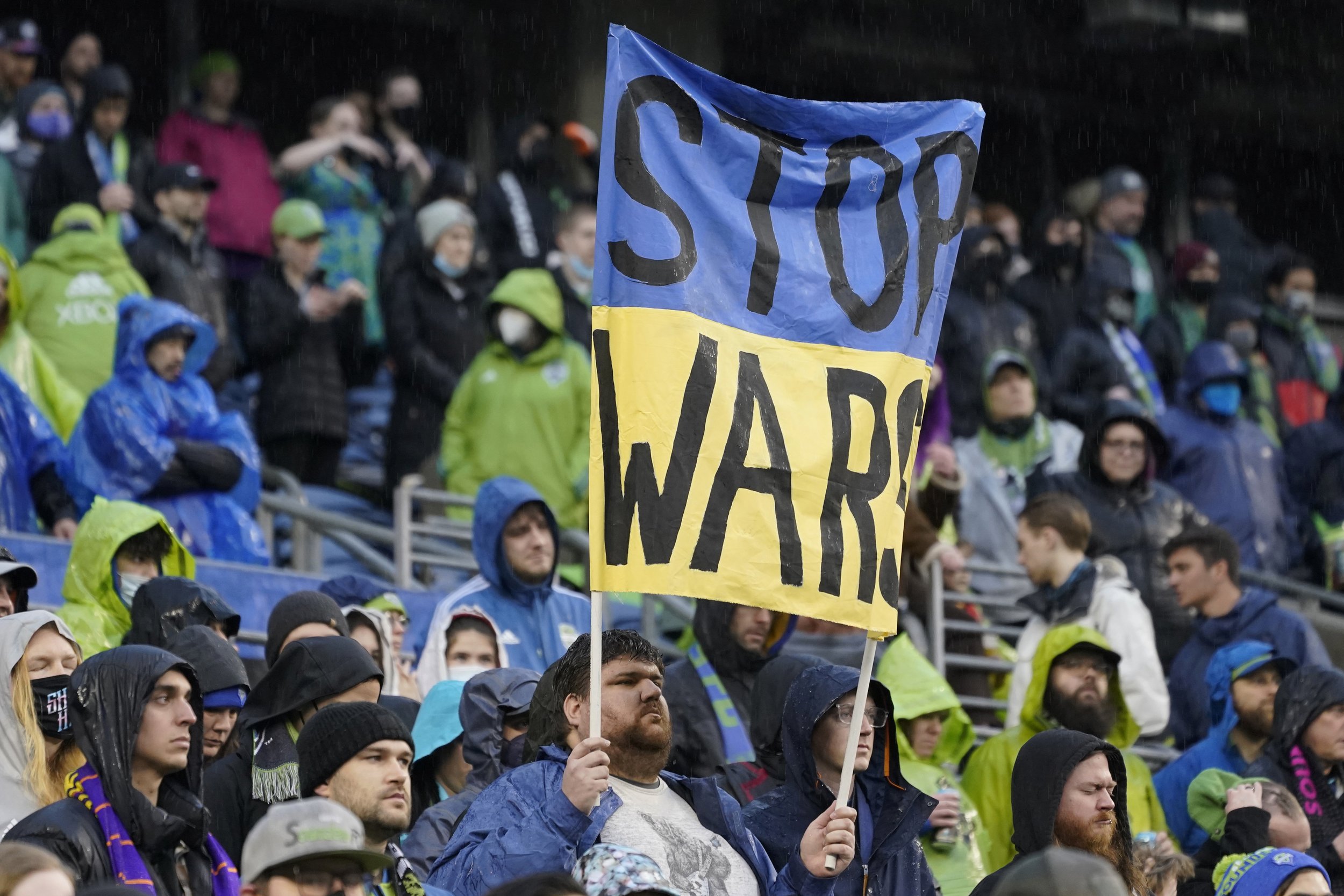  A Seattle Sounders supporter holds a sign that reads "Stop Wars" during a moment of silence for victims of the war in Ukraine, before the start of an MLS soccer match between the Sounders and Nashville SC, Sunday, Feb. 27, 2022, in Seattle. (AP Phot
