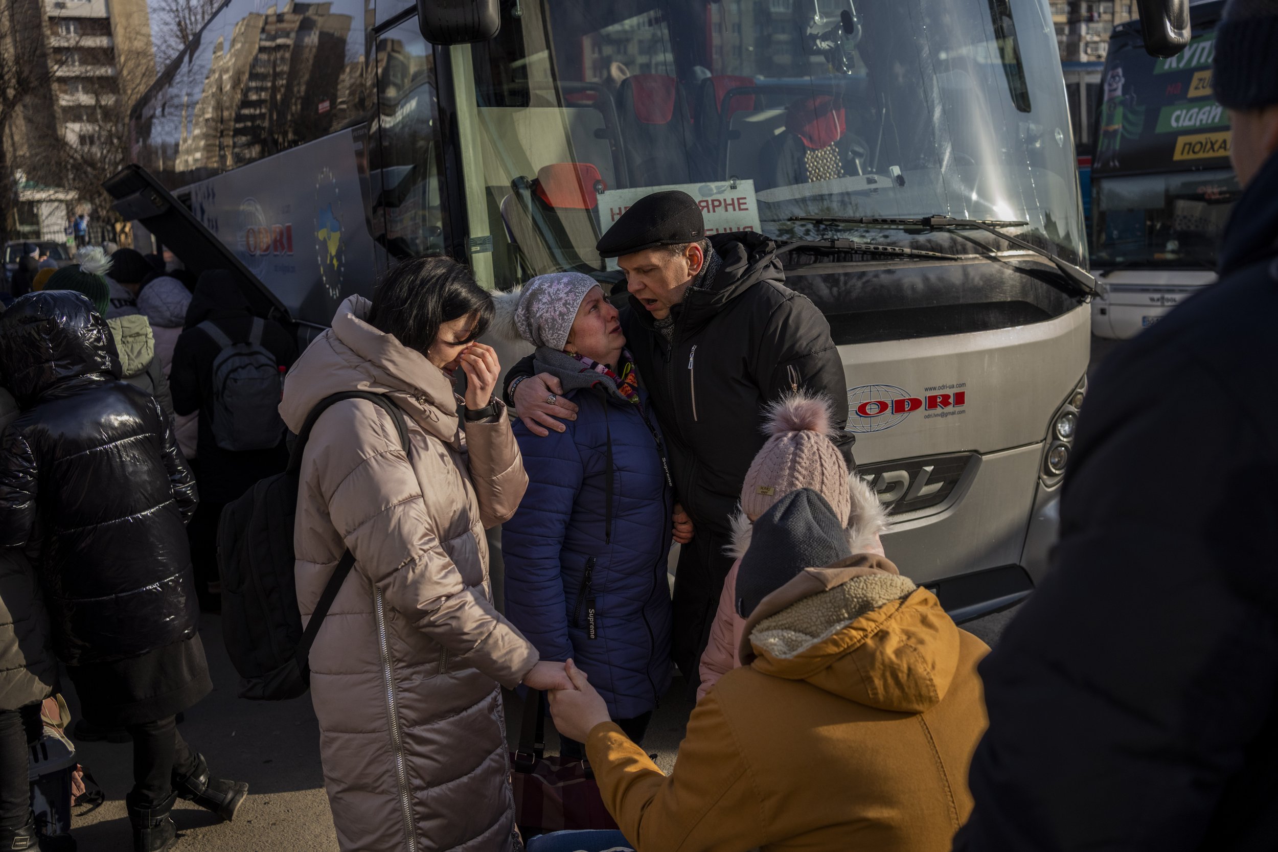  Ukrainian families say goodbye as they prepare to board a bus to Poland at Lviv bus main station, western Ukraine, Tuesday, March 1, 2022. (AP Photo/Bernat Armangue) 