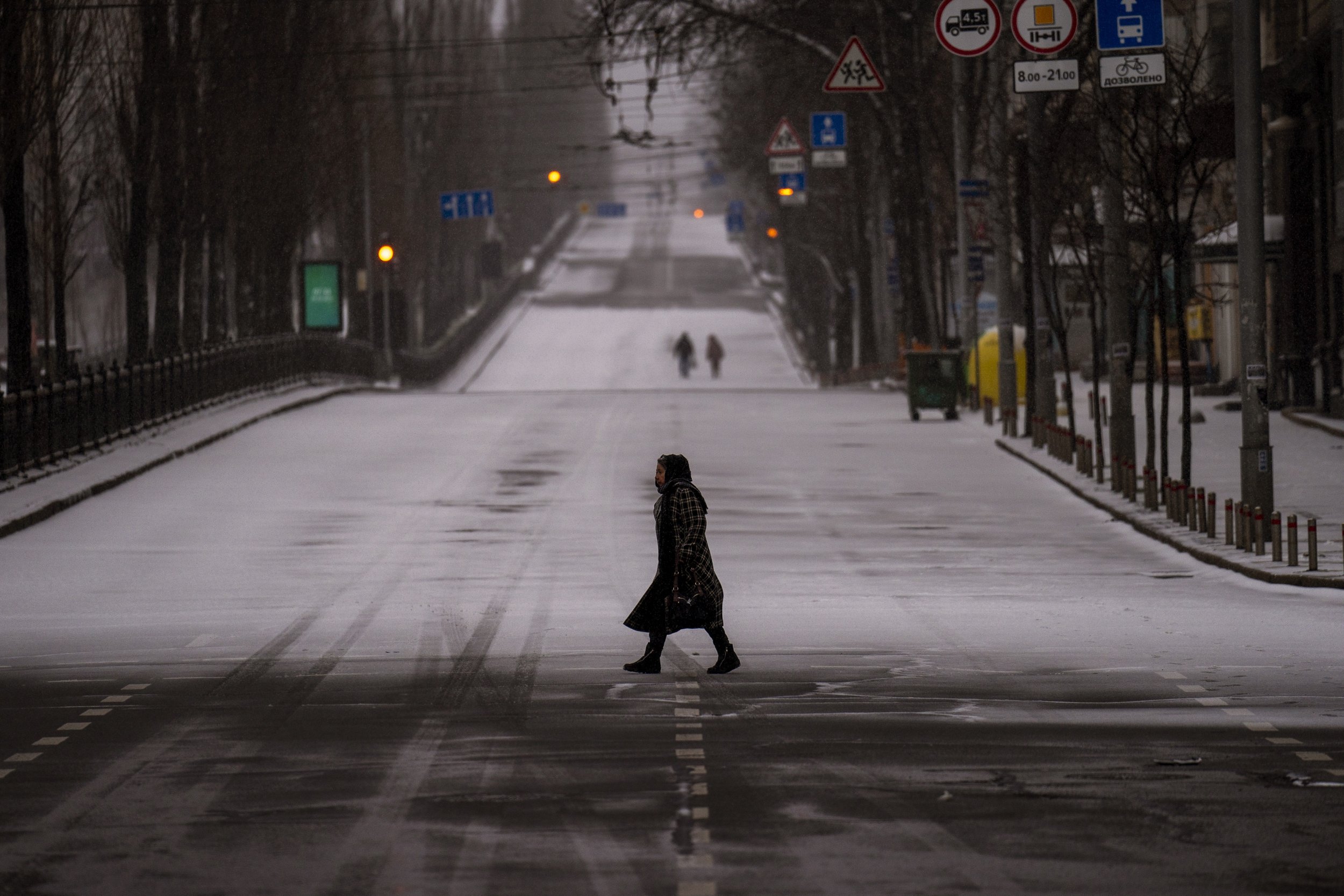  People walk along an empty road during curfew, in Kyiv, Ukraine, Tuesday, March 1, 2022. (AP Photo/Emilio Morenatti) 