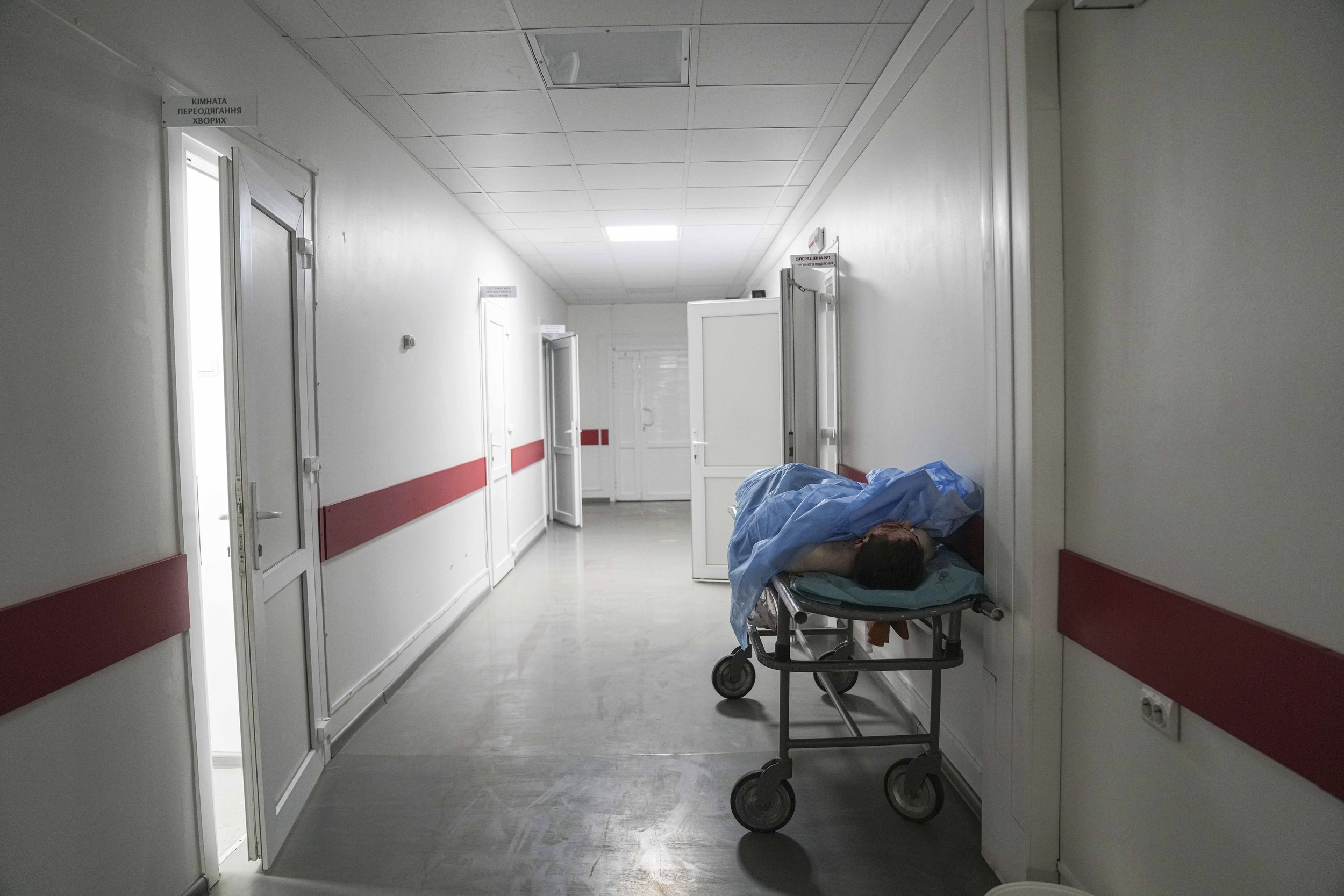  The dead body of a victim from shelling in a residential area lies on a stretcher in a corridor in a maternity hospital converted into a medical ward in Mariupol, Ukraine, Tuesday, March 1, 2022. (AP Photo/Evgeniy Maloletka) 