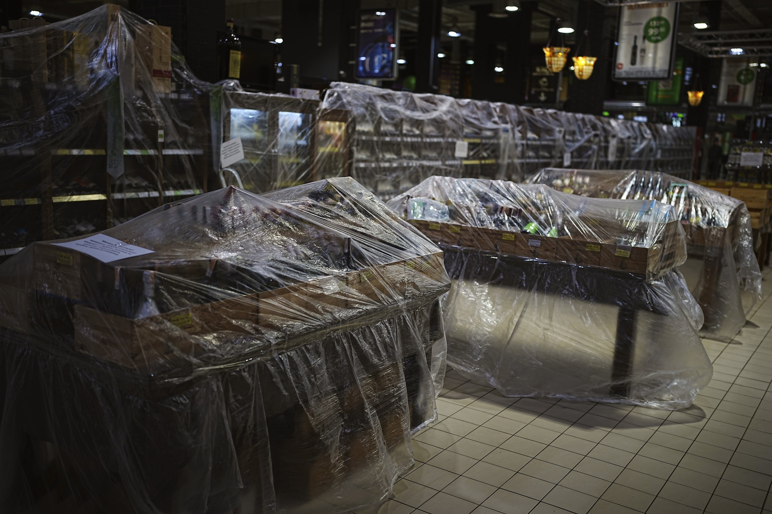  Plastic sheeting wraps shelves with alcoholic beverages banned for sale in a supermarket in Kyiv, Ukraine, Tuesday, March 1, 2022. (AP Photo/Emilio Morenatti) 