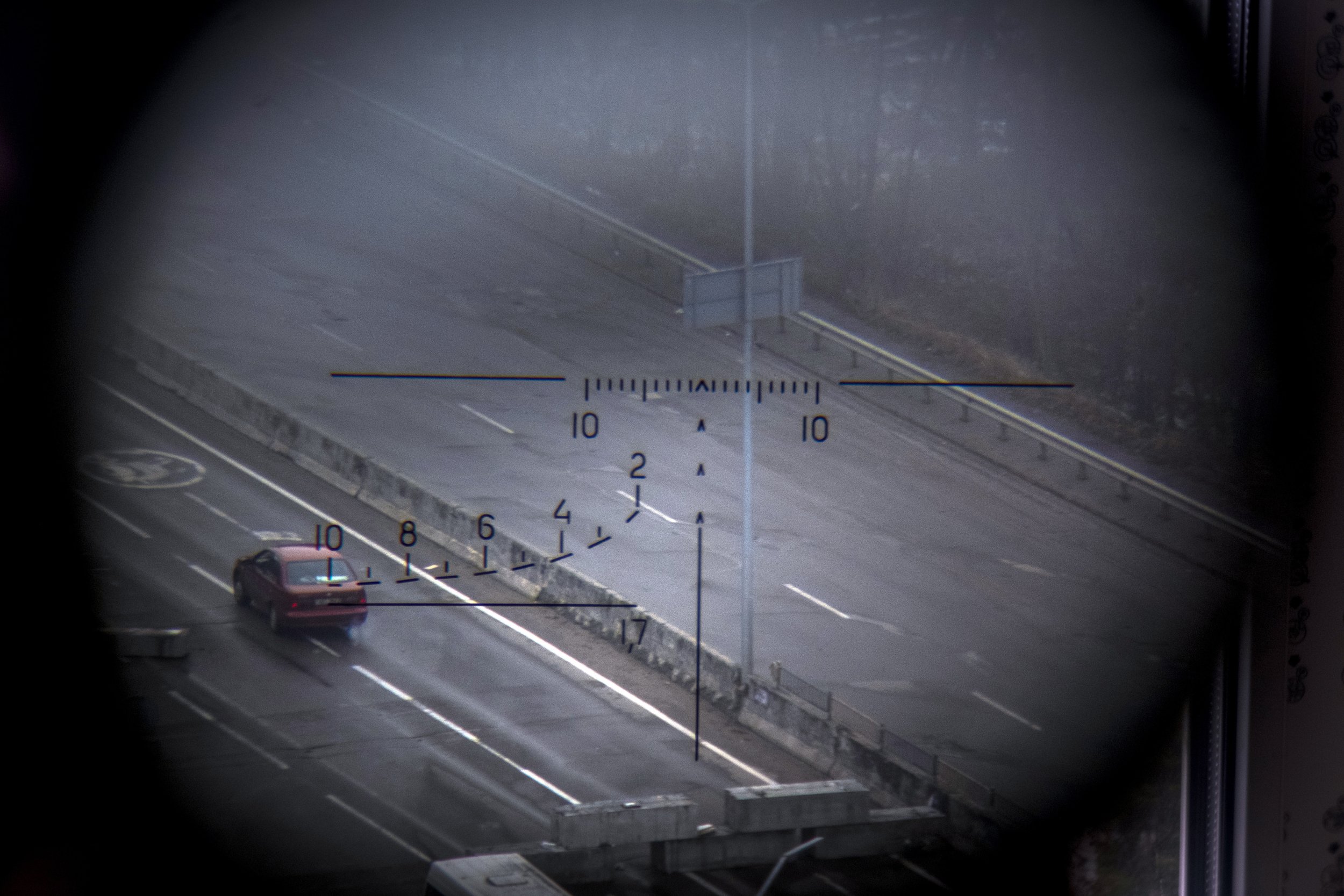  A car driving along a road is visible from a Ukrainian army position through the viewfinder of a Dragunov sniper rifle in the northern part of Kyiv, Ukraine, Tuesday, March 1, 2022. (AP Photo/Ricard Garcia Vilanova) 